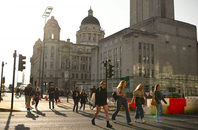 Sejumlah warga berjalan tanpa masker di wilayah Liverpool, Inggris.