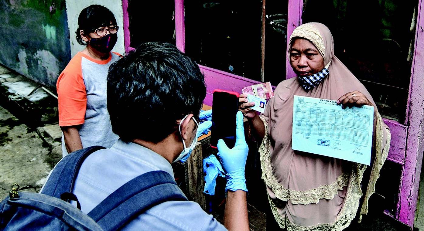 PENYALURAN BST: Petugas dari PT Pos Indonesia menyalurkan bansos tunai Rp300 ribu kepada warga RW 05, Kenari, Jakarta Pusat, kemarin.