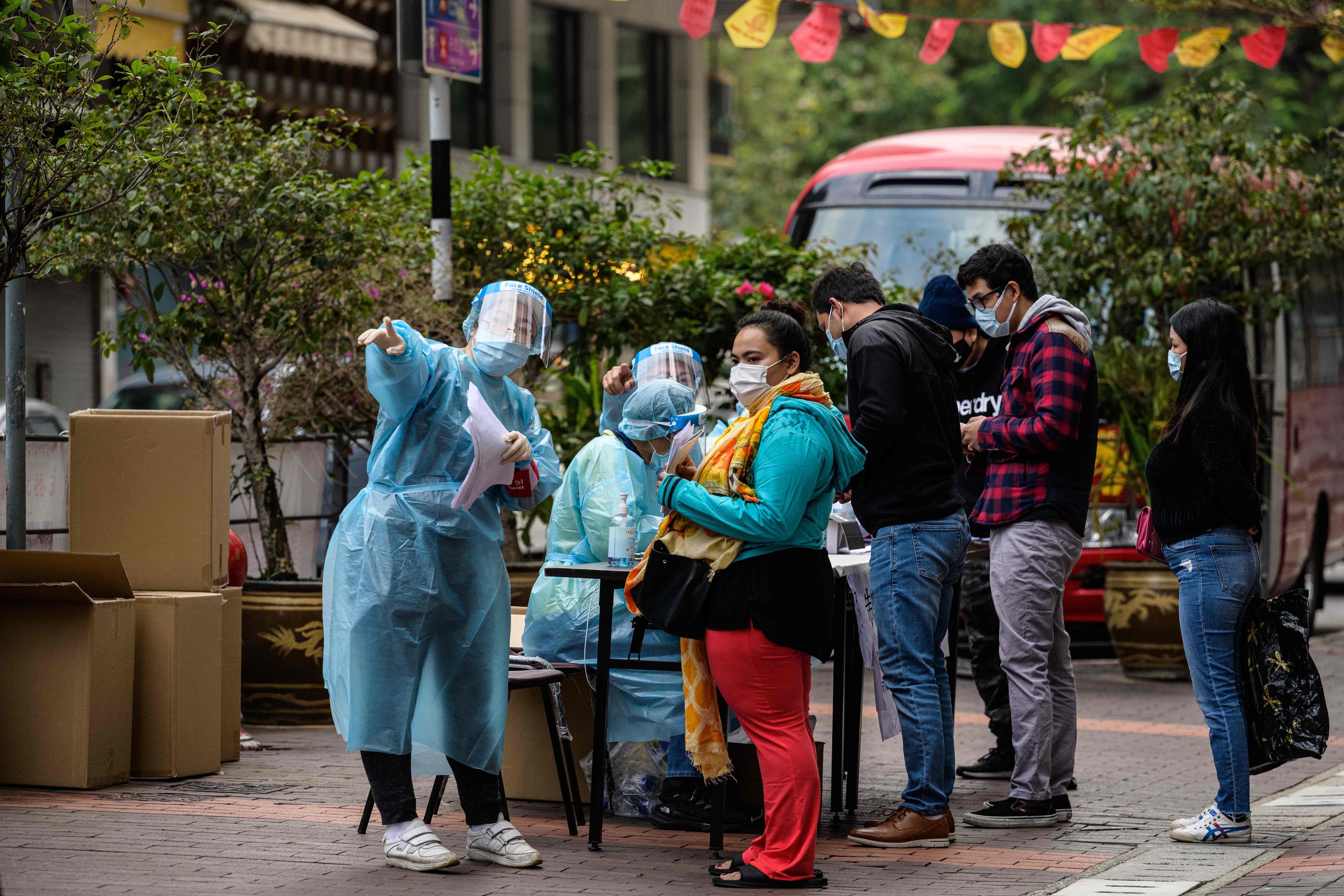 Petugas medis dengan mengenakan alat pelindung diri memeriksa warga di Distrik Jordan, Kowloon, Hong Kong, Kamis (21/1). 