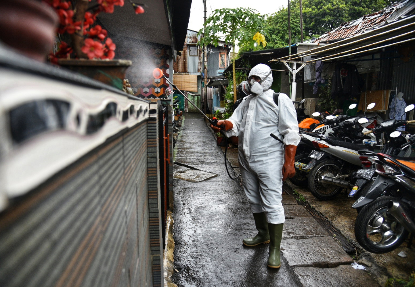  Petugas dari Palang Merah Indonesia (PMI) Kecamatan Menteng melakukan penyemprotan cairan disinfektan di kawasan yang menjadi zona merah