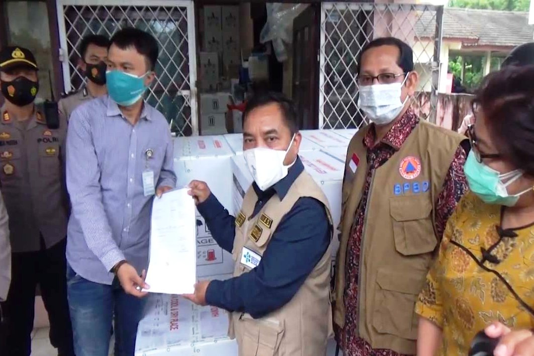 Plt Kepala Dinas Kesehatan Provinsi Jambi Raflizar (pakai rompi) menerima dokumen serah terima 20 ribu dosis vaksin Sinovac.