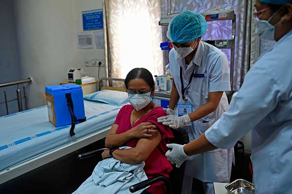 Petugas medis menyuntikan vaksin covid-19 kepada seorang pasien di India
