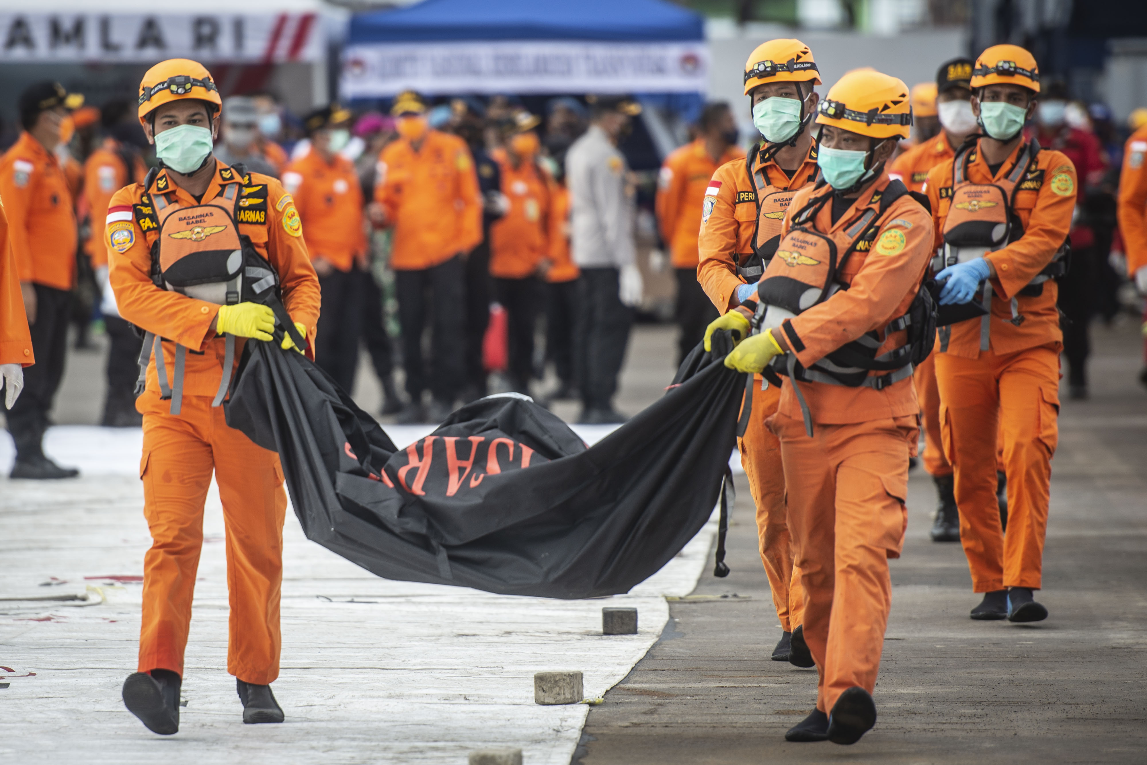 Personel Basarnas mengangkat kantong jenazah berisi objek temuan dari lokasi jatuhnya pesawat Sriwijaya Air SJ 182.