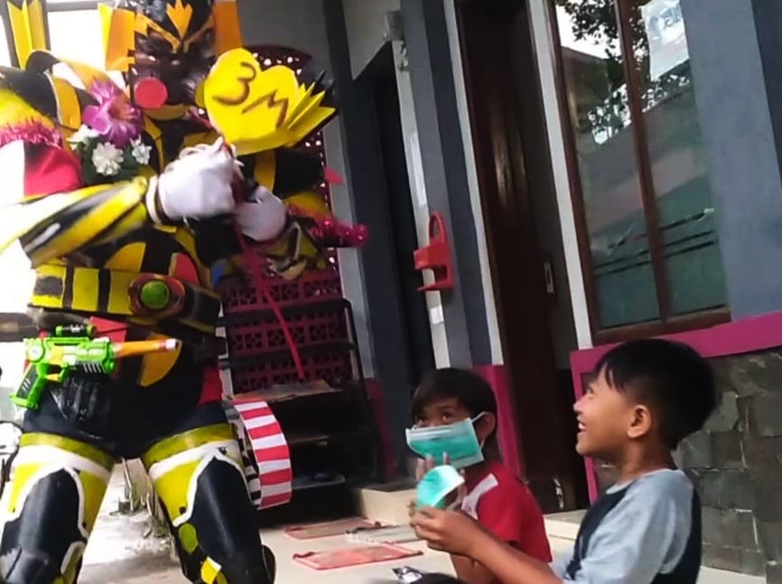  Herti Ruhiana, memakai replika kostum mirip Transformers memberi edukasi prokes 3M kepada warga di Lembang, Kabupaten Bandung Barat.