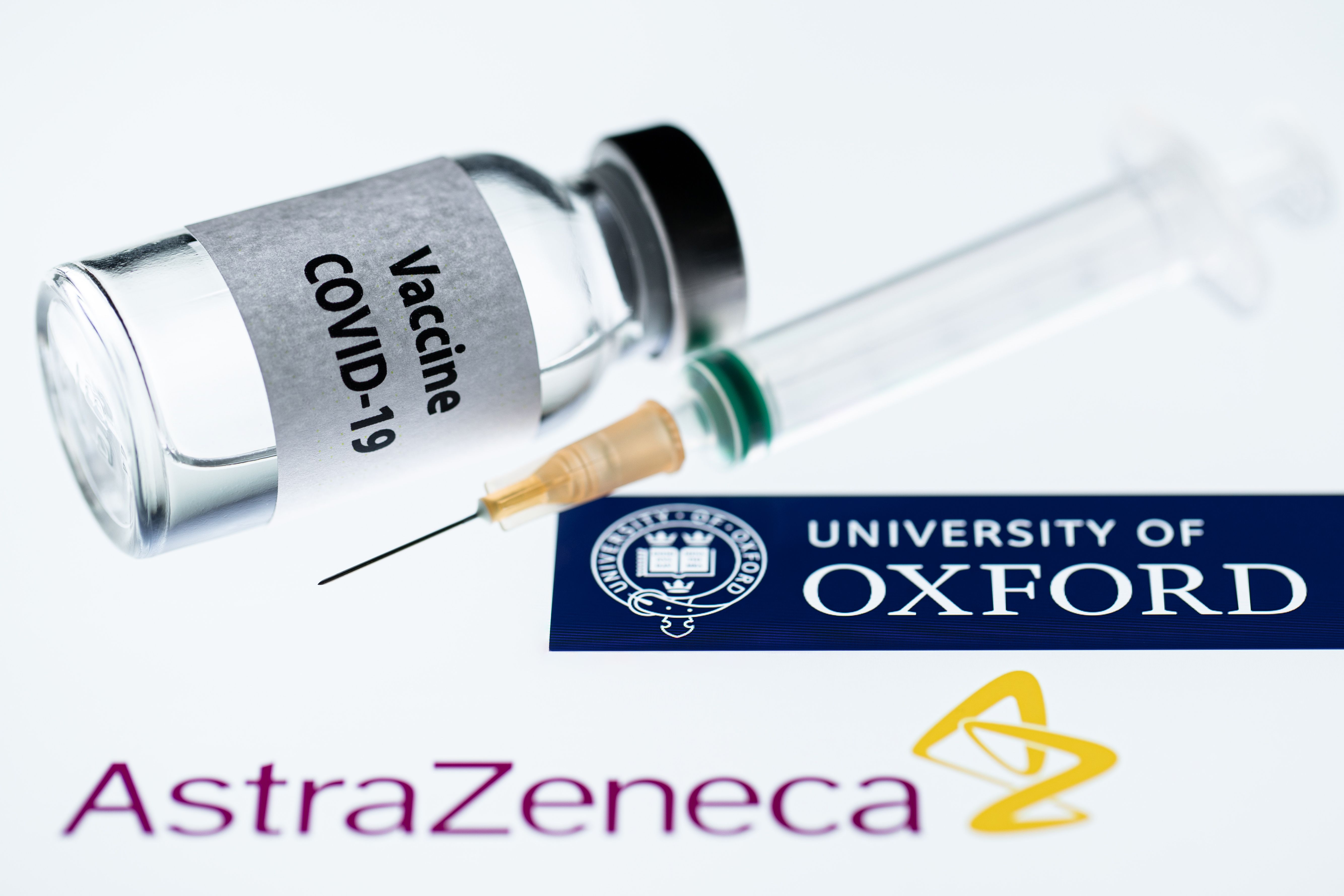 Foto ilustrasi yang menampilkan botol bertuliskan vaksin covid-19 dan logo AstraZeneca dan Universitas Oxford.