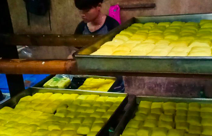 Pekerja mengemas tahu ke dalam plastik di pabrik tahu Desa Cikidang, Kecamatan Lembang, Rabu (30/12). 