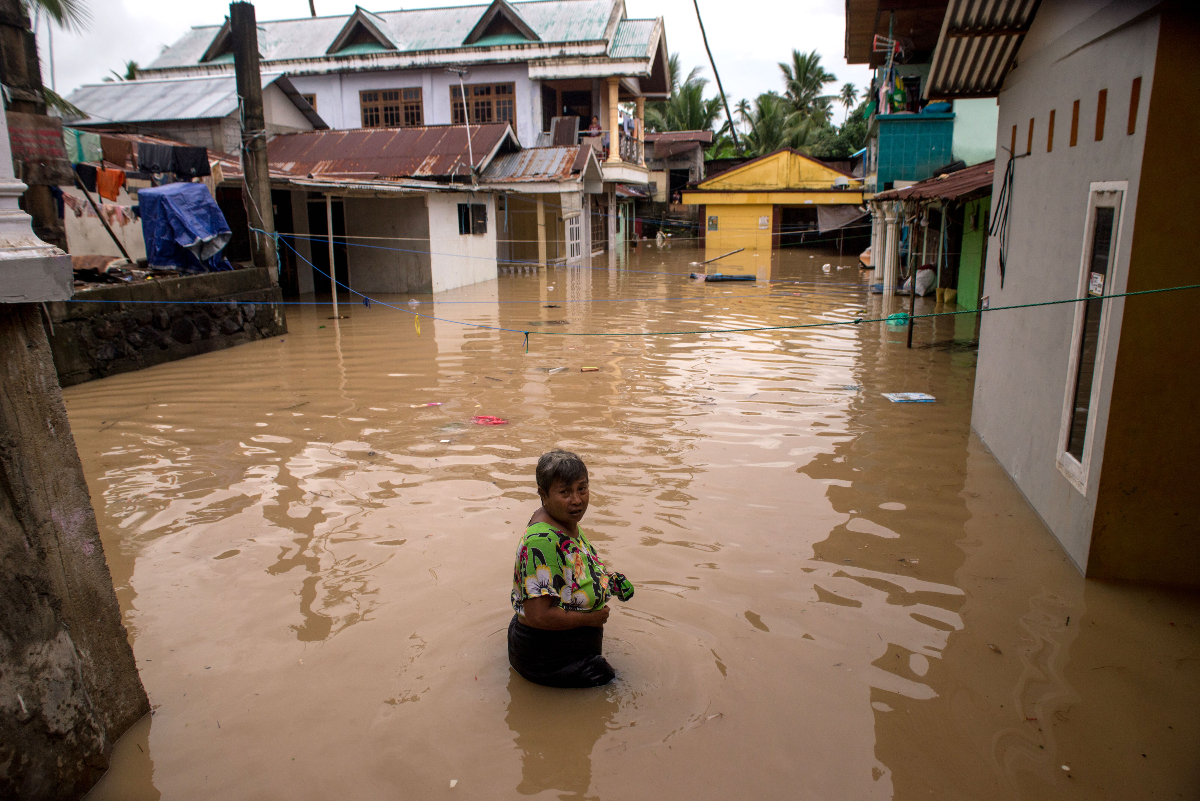 Warga melintasi banjir yang melanda kampung Mahawu, Manado, Sulawesi Utara.