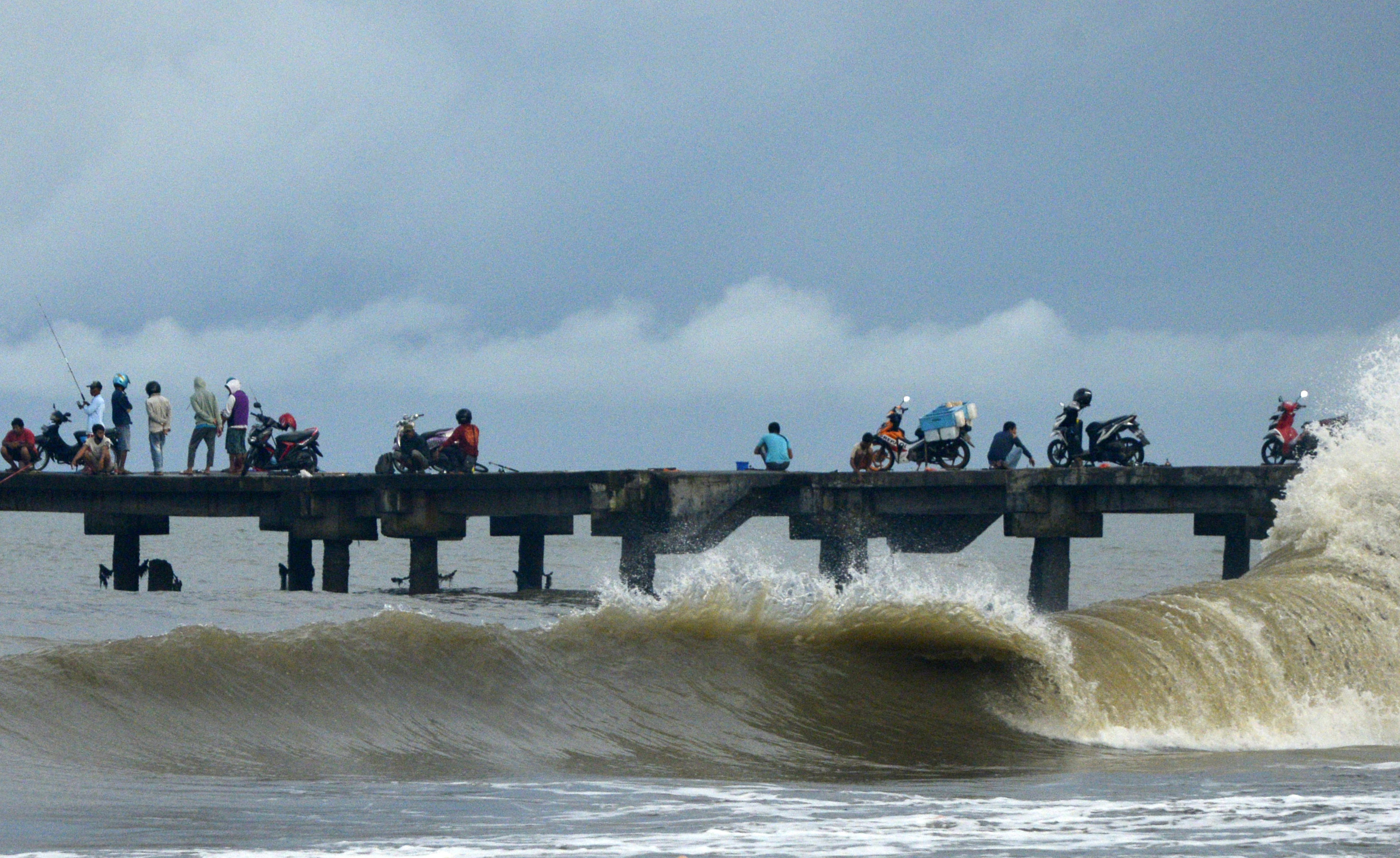  Sejumlah warga berada di sekitar dermaga saat gelombang tinggi di pesisir pantai Galesong Utara, Kabupaten Takalar, Sulsel, Kamis (31/12).