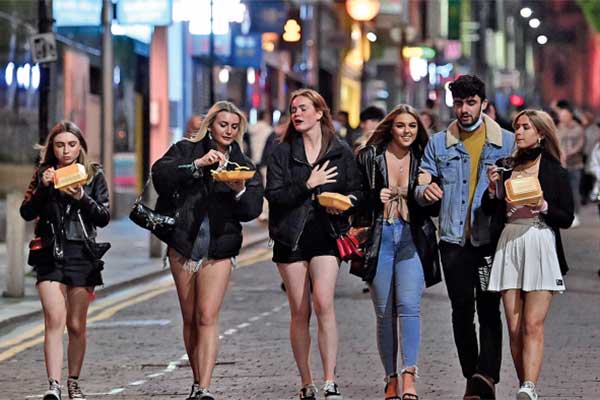 Pejalan kaki melintas di pusat kota sebelum pemberlakuan lokal lockdown di Liverpool, barat laut Inggris.