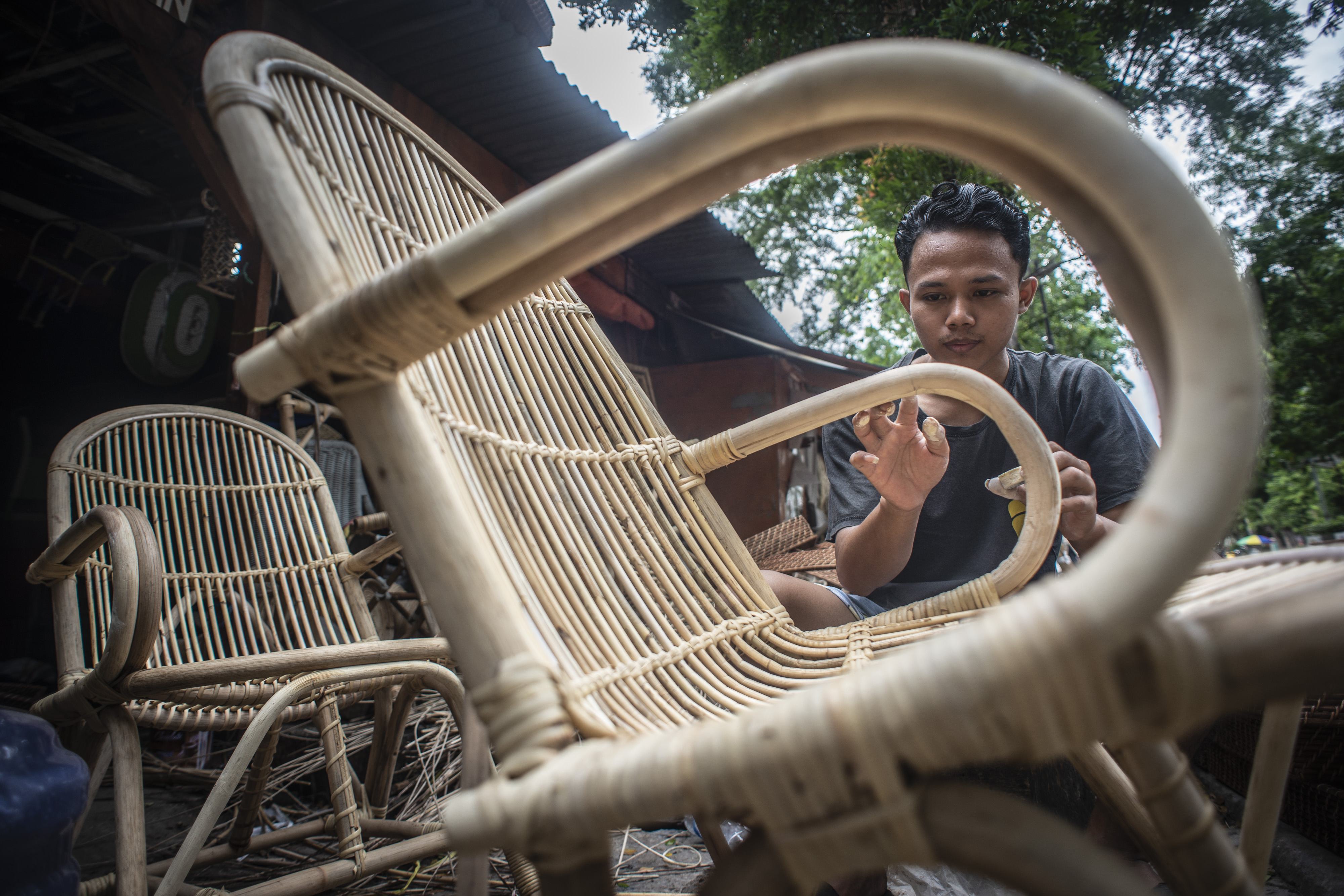 Pekerja memproduksi kursi berbahan rotan di kawasan Grogol, Jakarta, yang mendapat realisasi program PEN untuk sektor UMKM. 