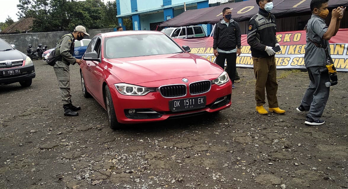 Petugas gabungan memeriksa pengendara yang hendak memasuki wilayah Kabupaten Sukabumi, Jawa Barat, di perbatasan dengan Kabupaten Cianjur.