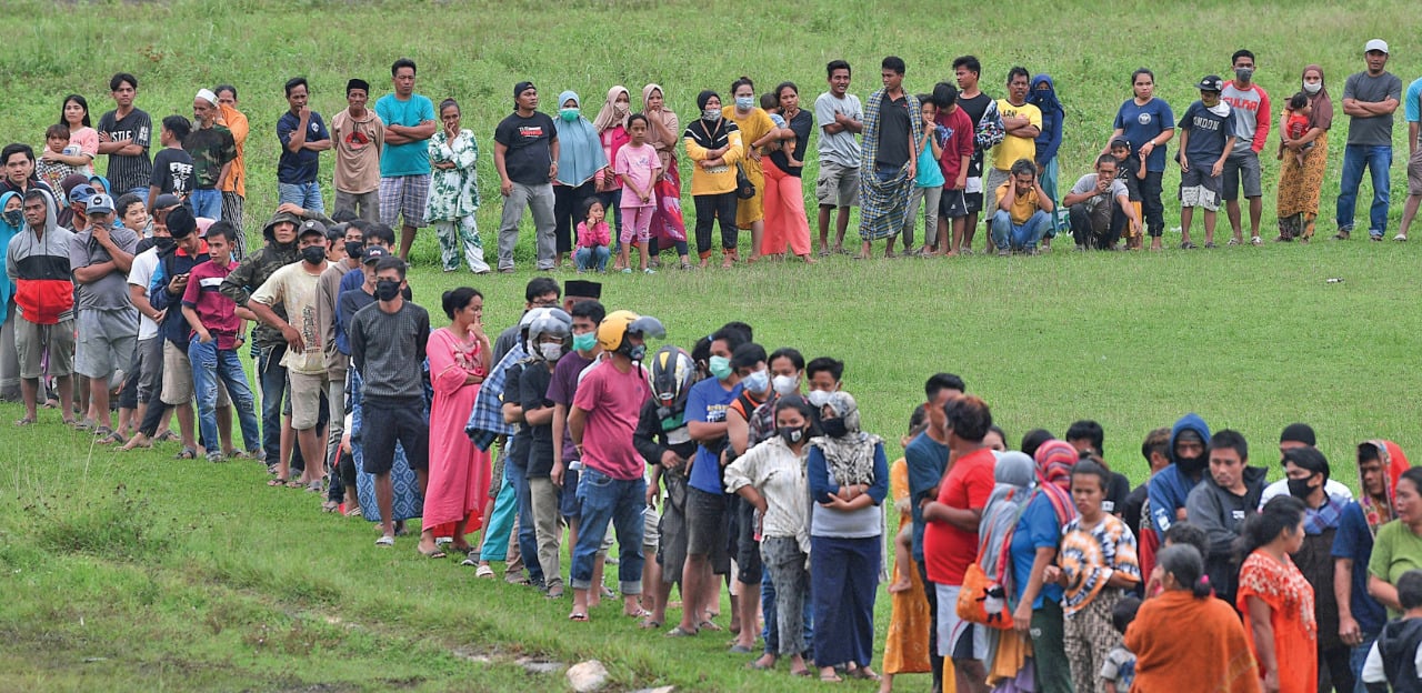Pengungsi korban gempa antre untuk mendapatkan bantuan logistik dari TNI-AD di Stadion Manakarra, Mamuju, Sulawesi Barat, kemarin.