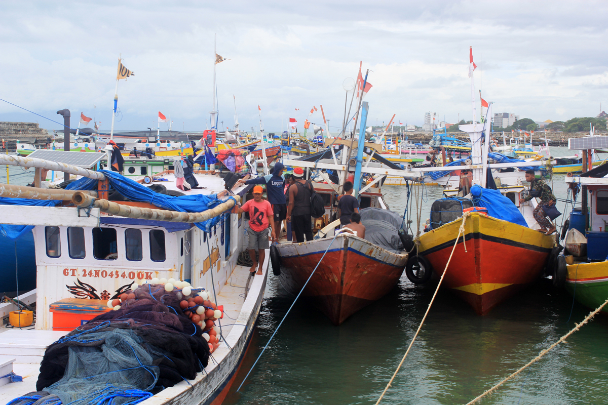 Nelayan menambatkan perahu di kolam labuh TPI Kelurahan Fatubesi, Kota Kupang, Nusa Tenggara Timur (NTT), Kamis (28/1).