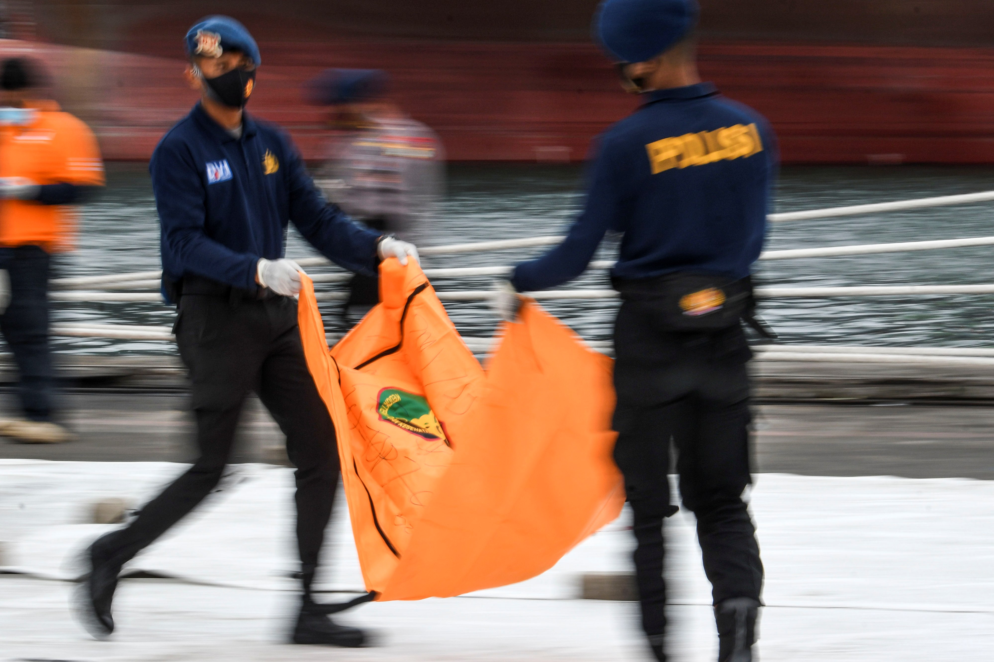 Anggota Polri membawa kantong jenazah dari korban pesawat Sriwijaya Air nomor penerbangan SJ 182 rute Jakarta-Pontianak di Dermaga JICT.