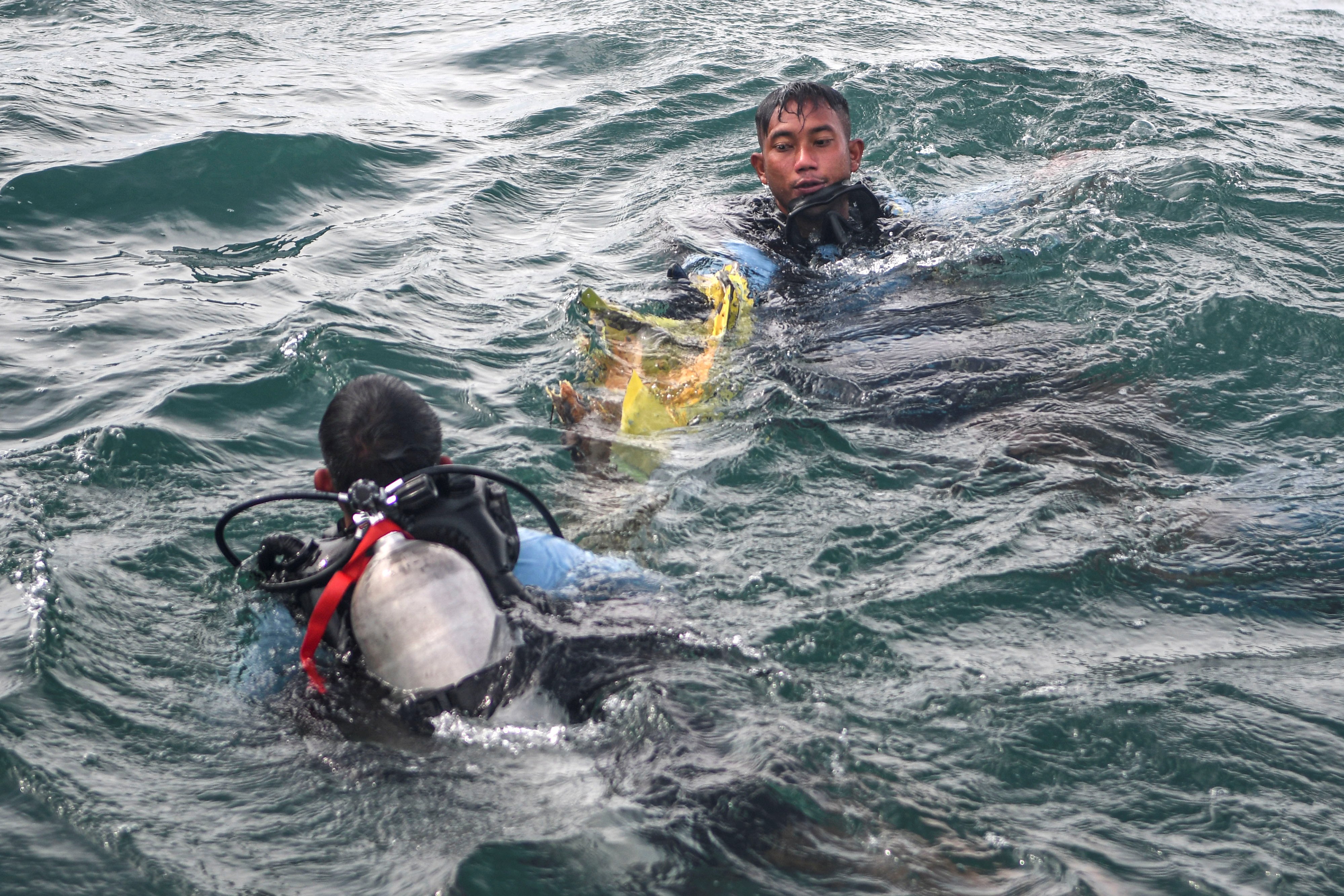 Prajurit Satuan Komando Pasukan Katak Armada 1 berusaha mengangkat puing pesawat SJ 182 dari dasar perairan Kepulauan Seribu, Senin (11/1).