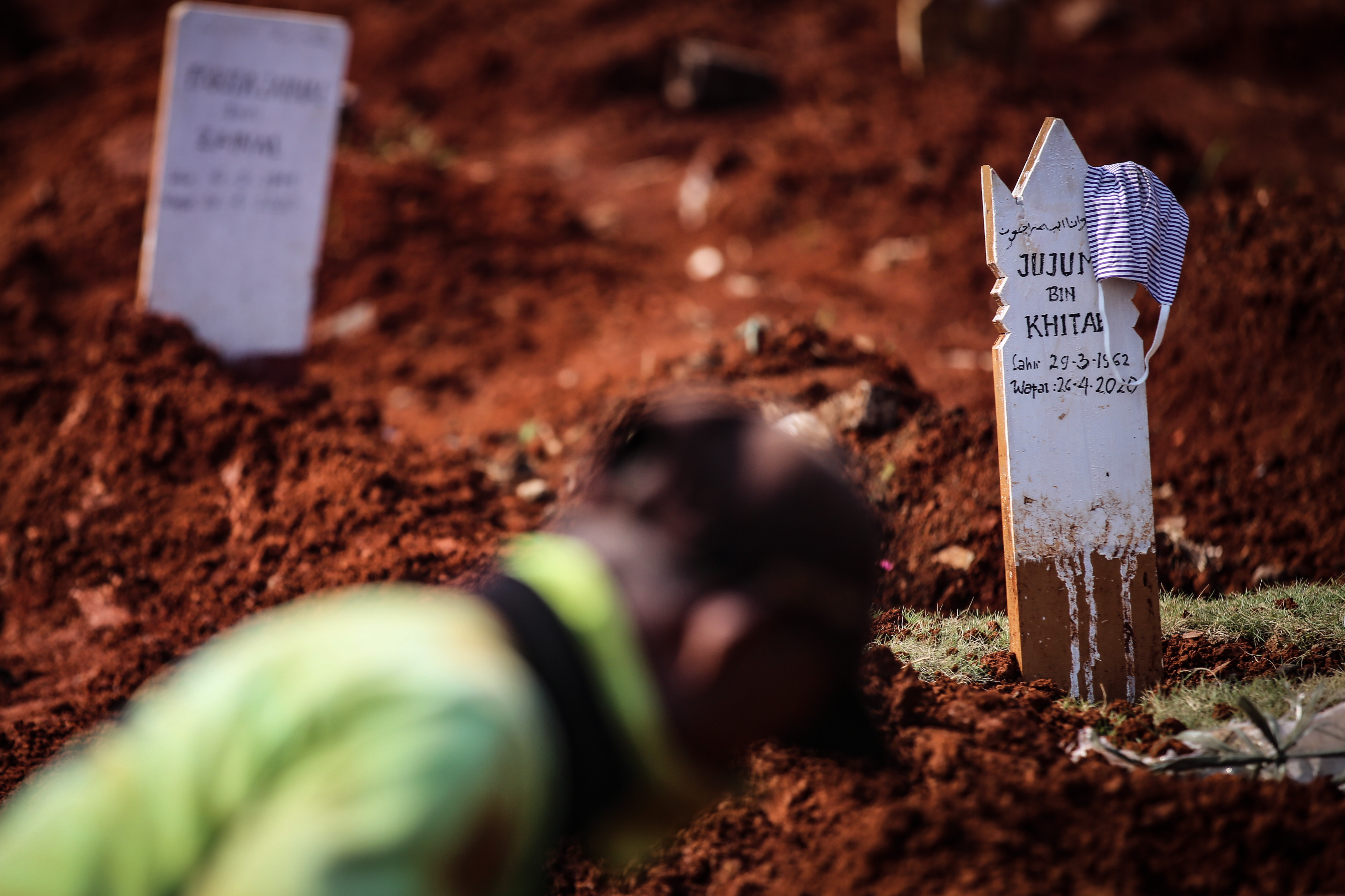 Masker ditinggalkan di makam jenazah covid-19 di TPU Pondok Ranggon, Jakarta, Kamis (7/5/2020). 