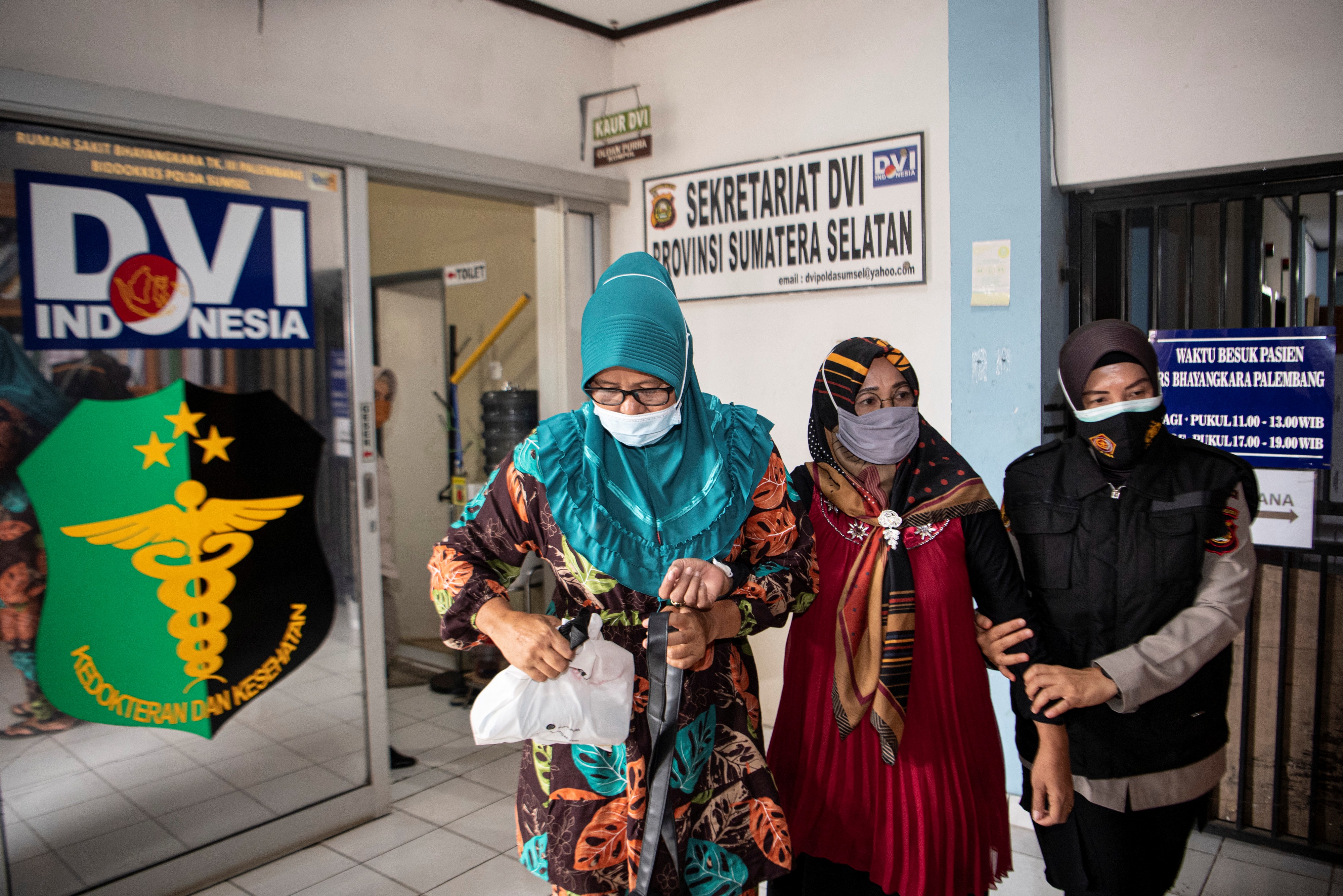 Anggota Polri menuntun Yusrilanita (tengah) selaku orangtua Indah Halimah Putri korban jatuhnya pesawat Sriwijaya Air SJ182 rute Jakarta-Pon