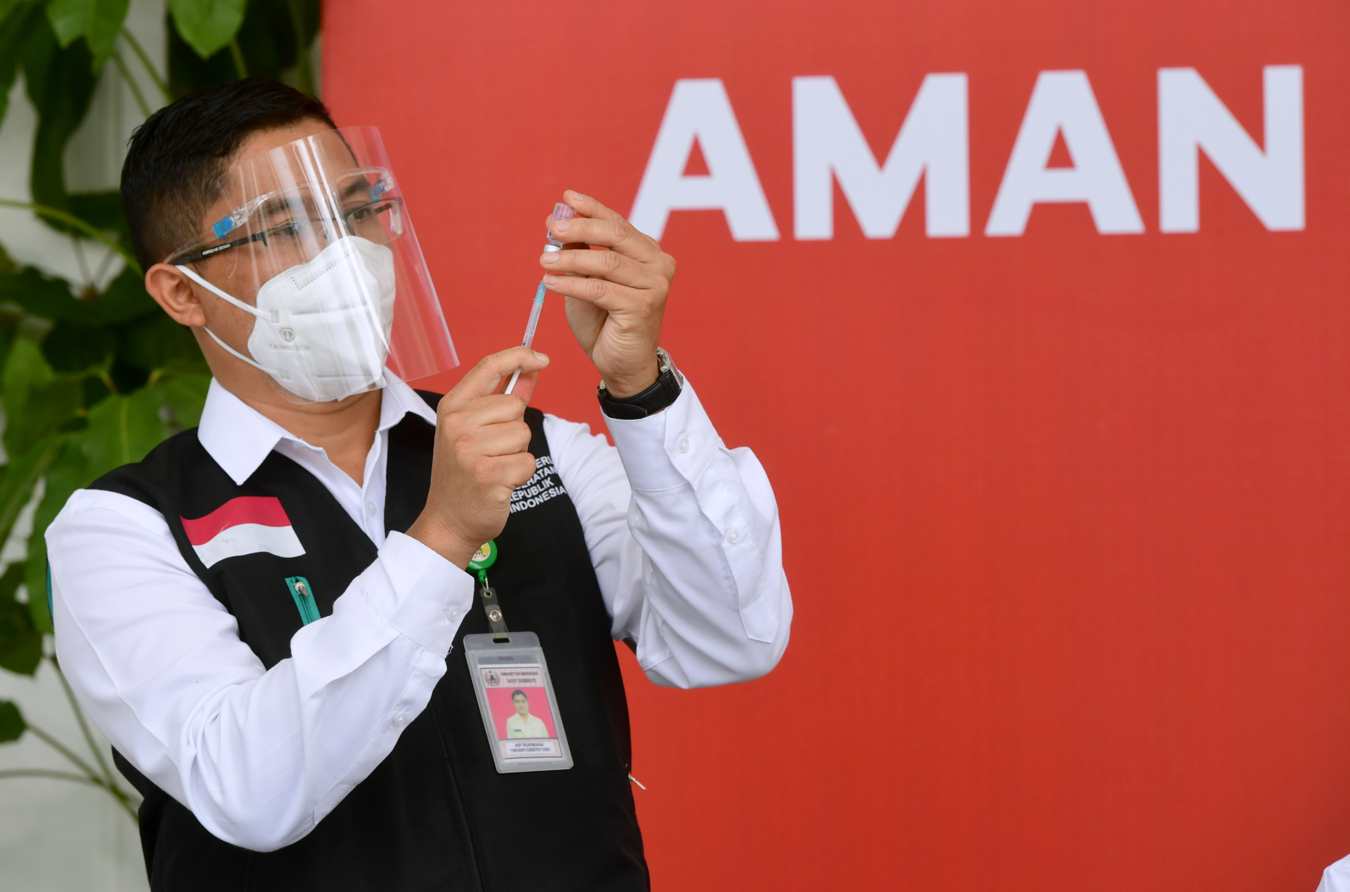 Peugas vaksinator sedang menyiapkan alat suntik vaksin covid-19