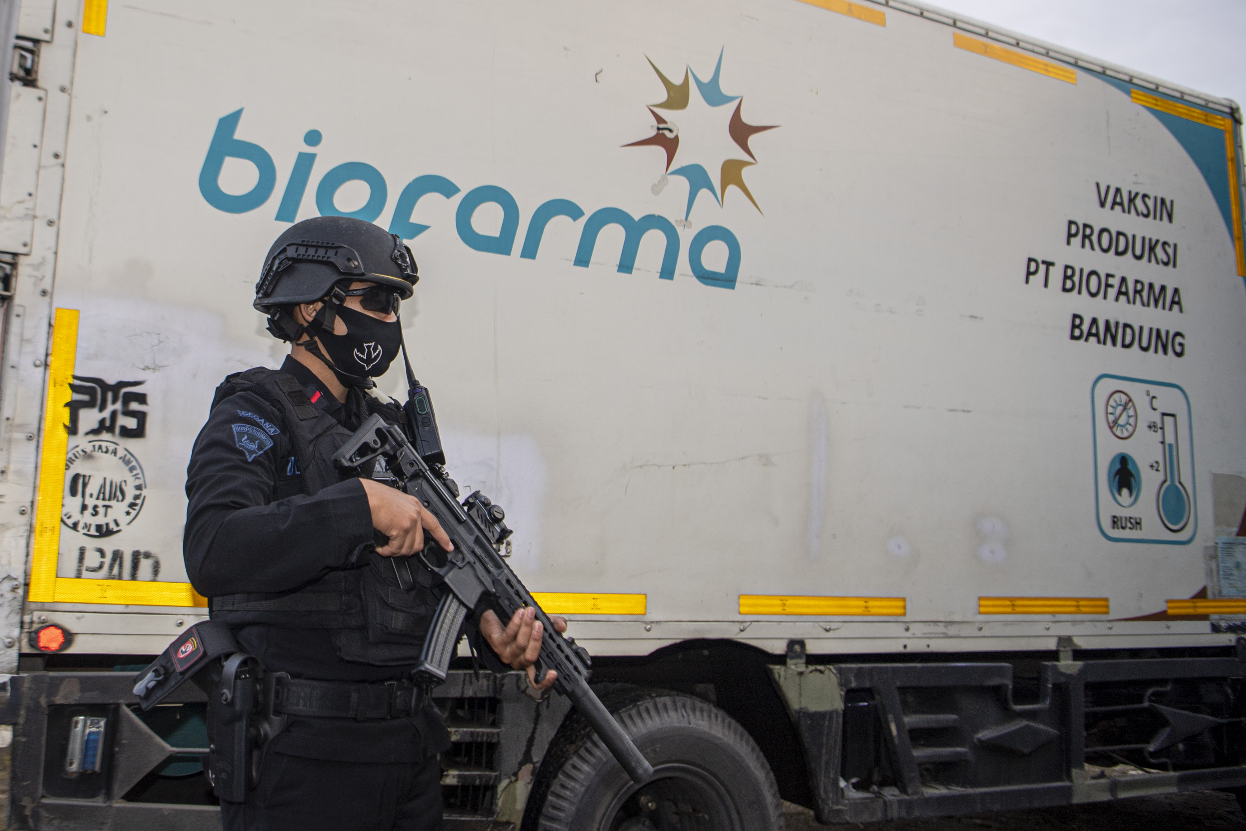 Ilustrasi--Anggota Brimob berjaga disamping truk yang berisi vaksin covid-19 Sinovac.