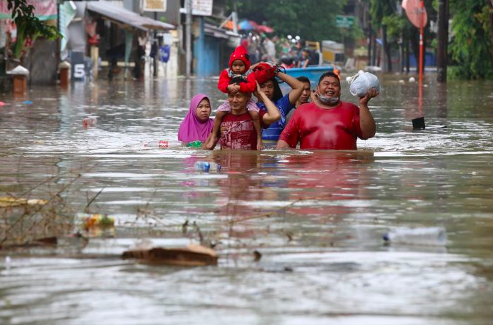 Warga menyelamatkan diri saat banjir melanda kawasan Bendungan Hilir, Jakarta.  