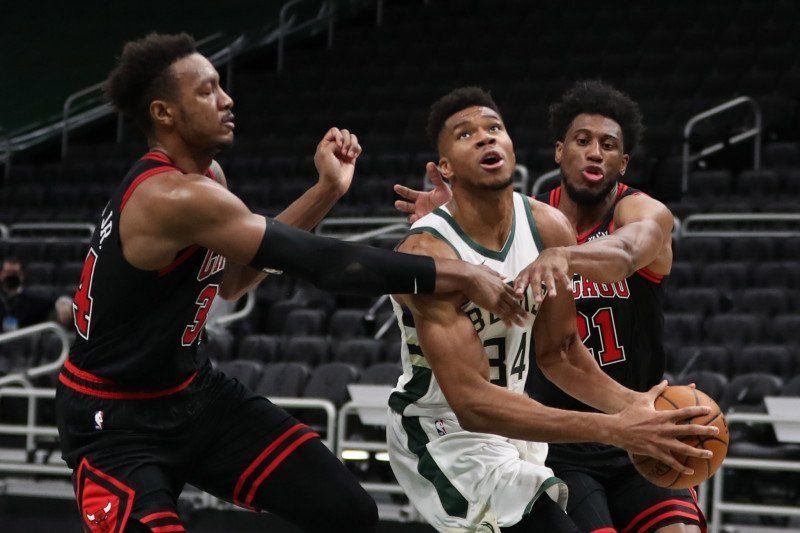 Forward Milwaukee Bucks Giannis Antetokounmpo (tengah) melakukan drive menuju ring basket menerobos hadangan dua pemain Chicago Bulls.