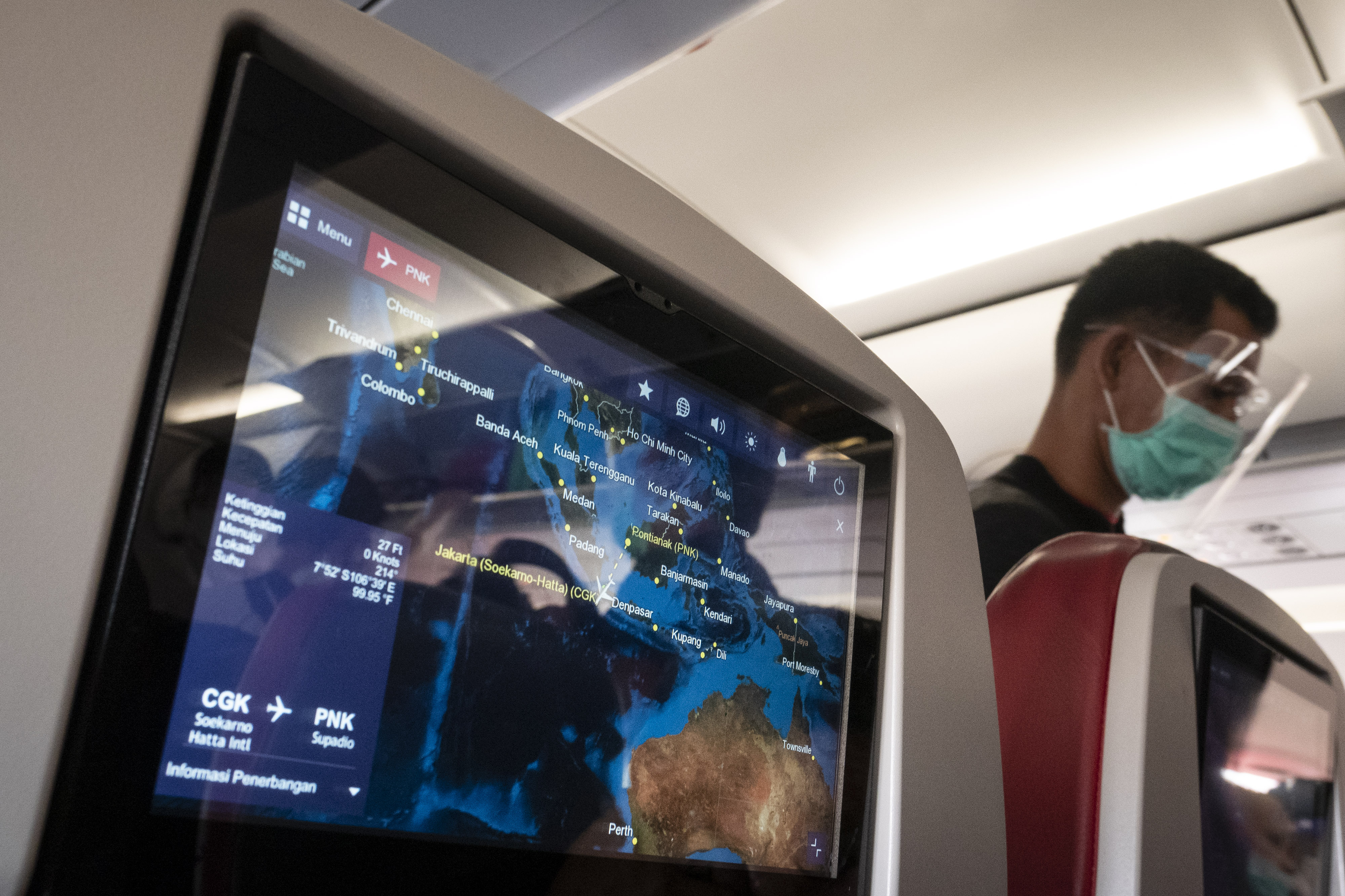 Penumpang pesawat mengenakan alat pelindung diri