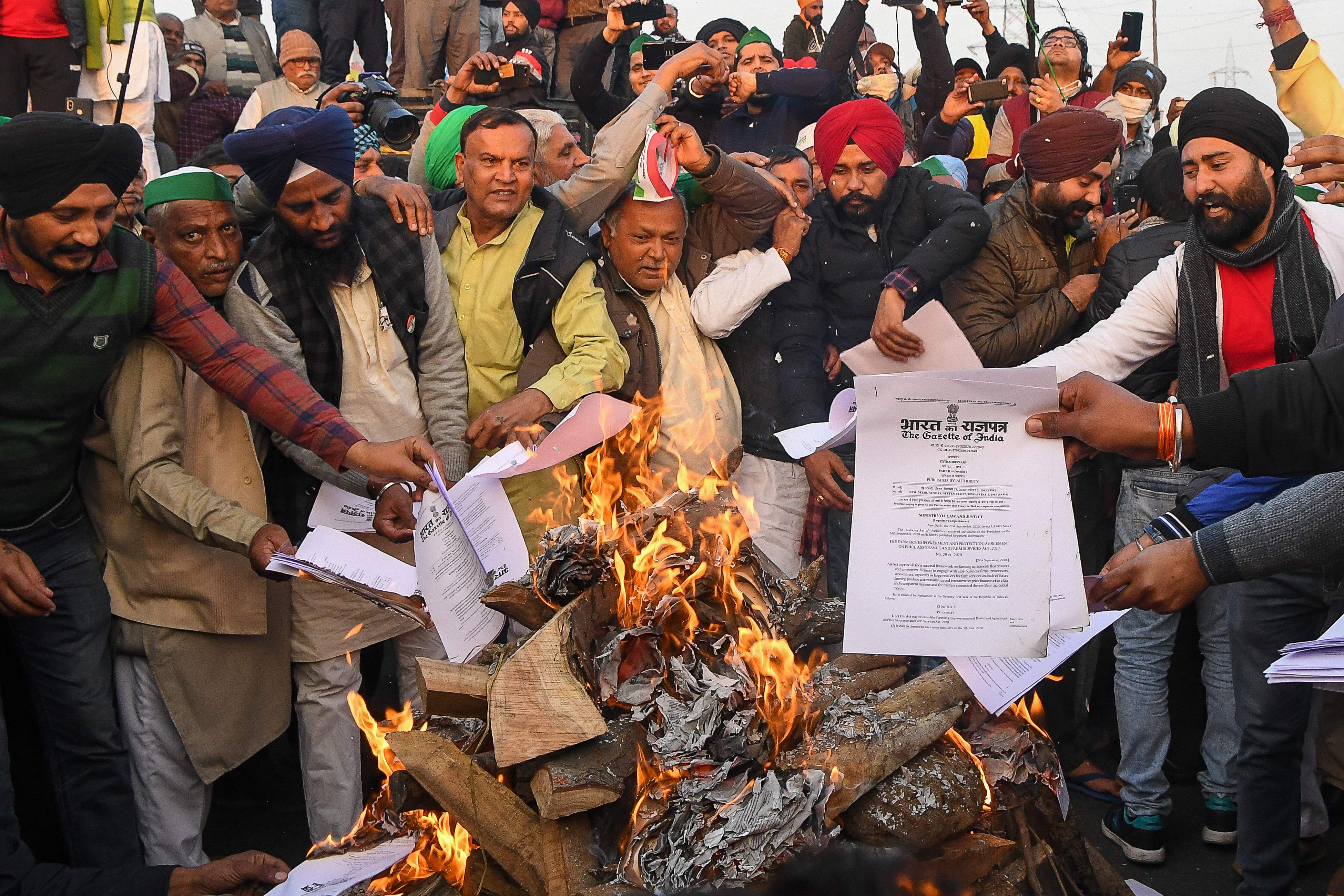 Petani membakar salinan UU reformasi pertanian sebagai bentuk penolakan di Ghaziabad, India, Rabu (13/1).