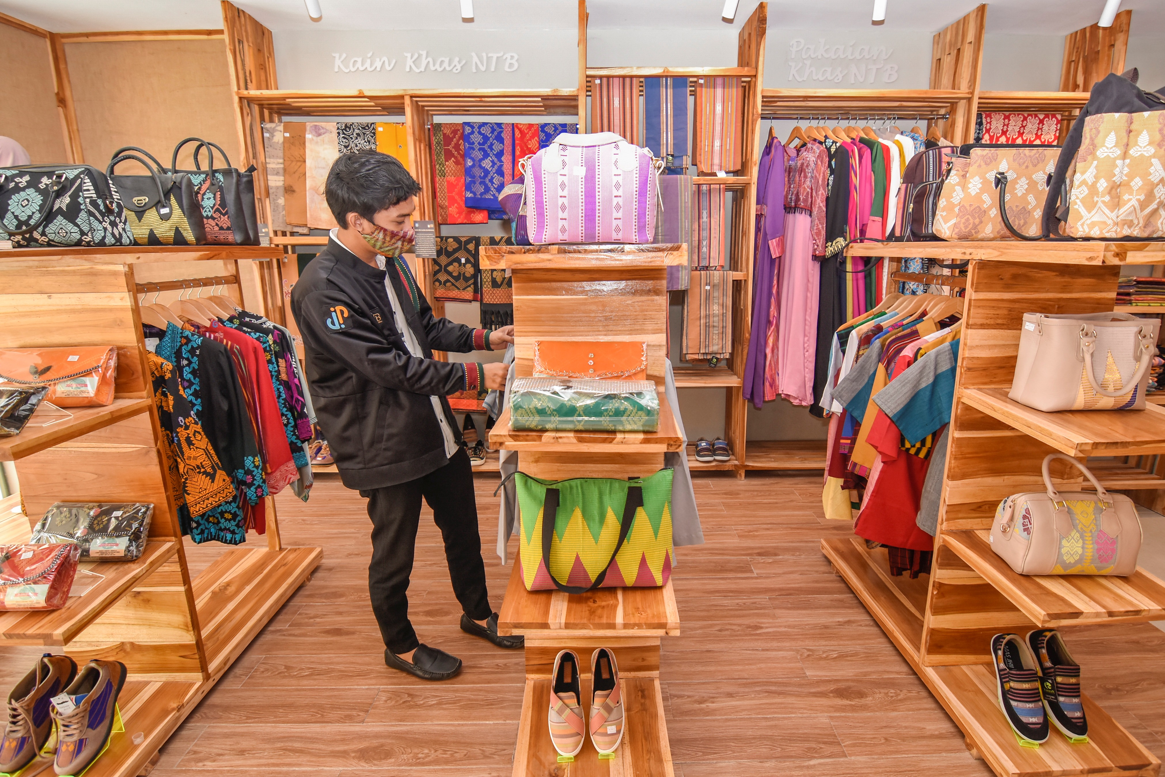 Karyawan merapikan produk UMKM lokal yang dijual di gerai NTB Mall, Kantor Dinas Perdagangan Provinsi NTB di Mataram, Rabu (27/1).