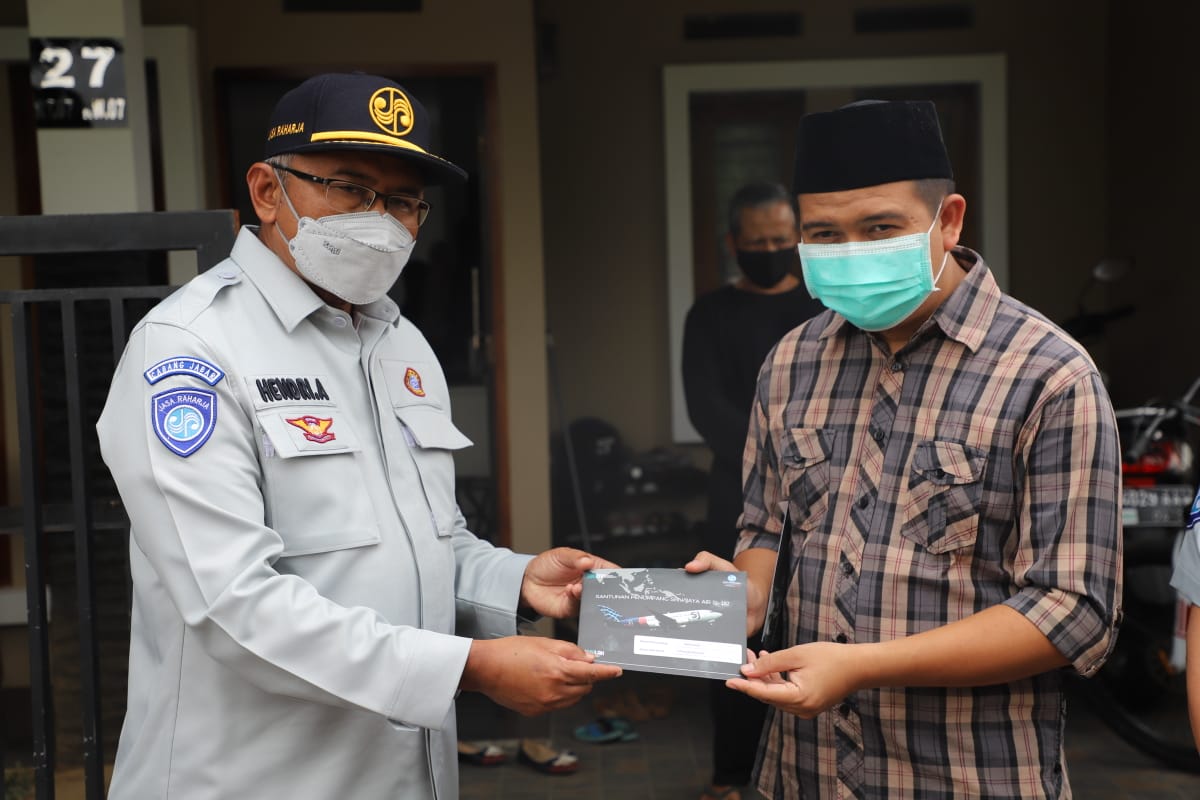 Kepala Cabang Jasa Raharja Jawa Barat Hendri Afrizal menyerahkan santunan kepada  Irfansyah Riyanto, ahli waris dua korban Sriwijaya Air. 