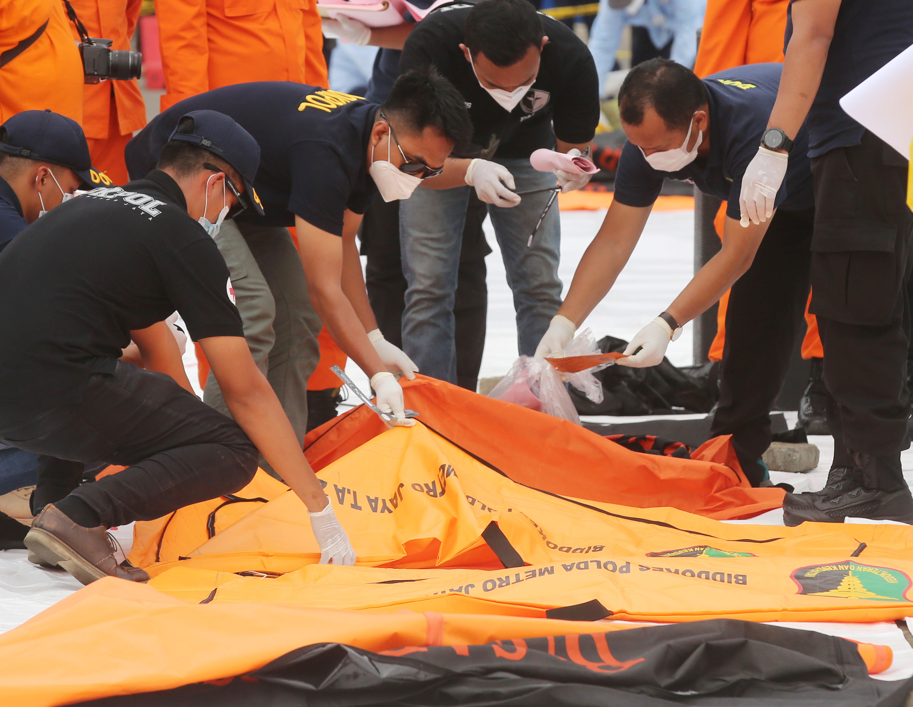 Petugas memeriksa kantong jenazah korban jatuhnya pesawat SJ-182