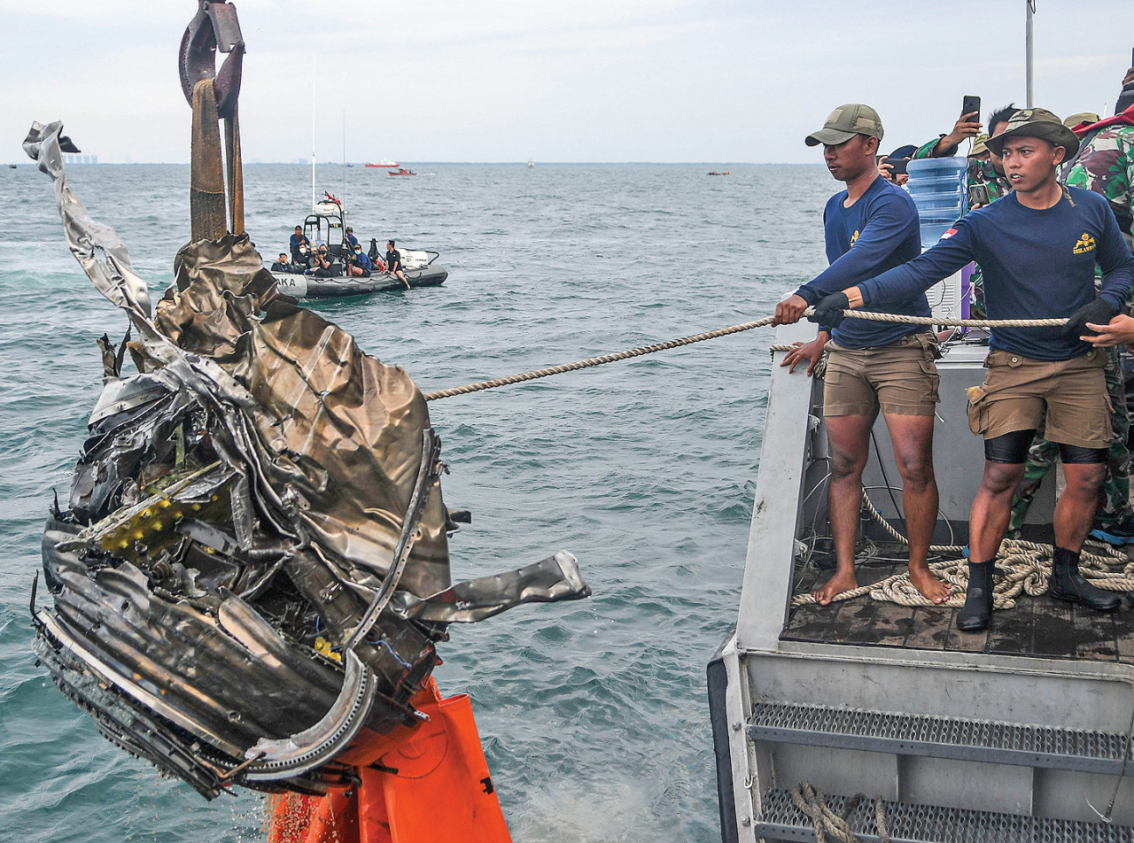 Penyelam TNI-AL menarik puing yang diduga turbin dari pesawat Sriwijaya Air SJ-182 ke atas KRI Rigel-933 di perairan Kepulauan Seribu.