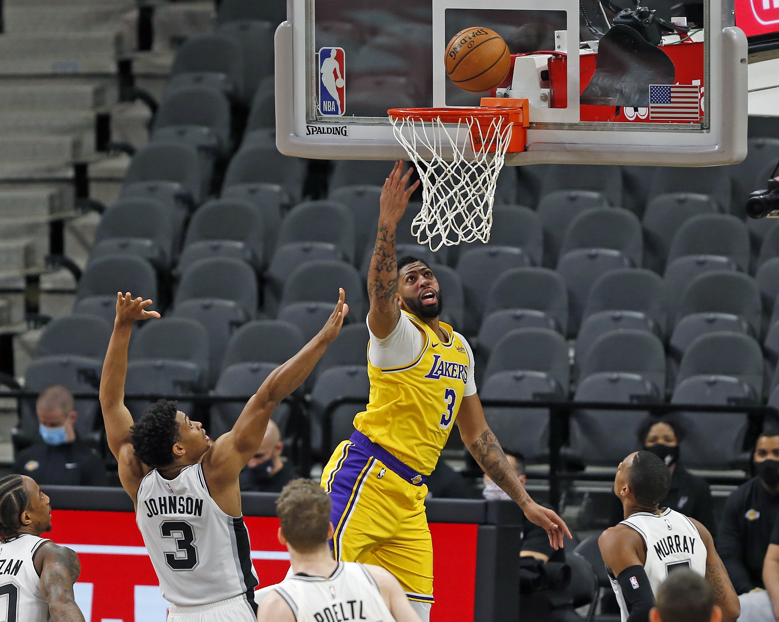 Anthony Davis (tengah) dari Los Angeles Lakers lakukan tembakan yang dihalangi Keldon Johnson (nomor 3) dari San Antonio Spurs.