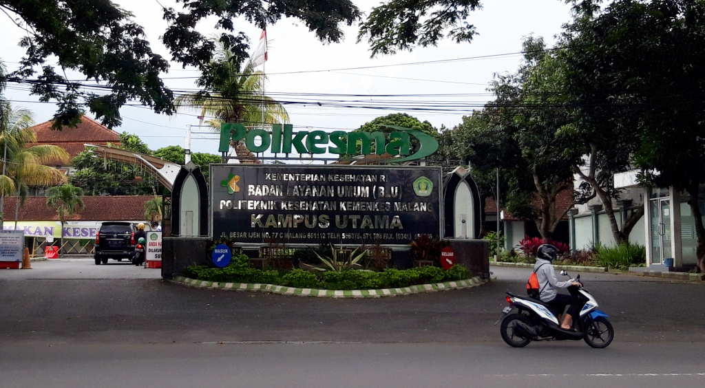 Warga melintas di depan kampus Polkesma, Kota Malang, Jawa Timur, yang dijadikan Rumah Sakit Lapangan Covid-19 Ijen Boulevard.