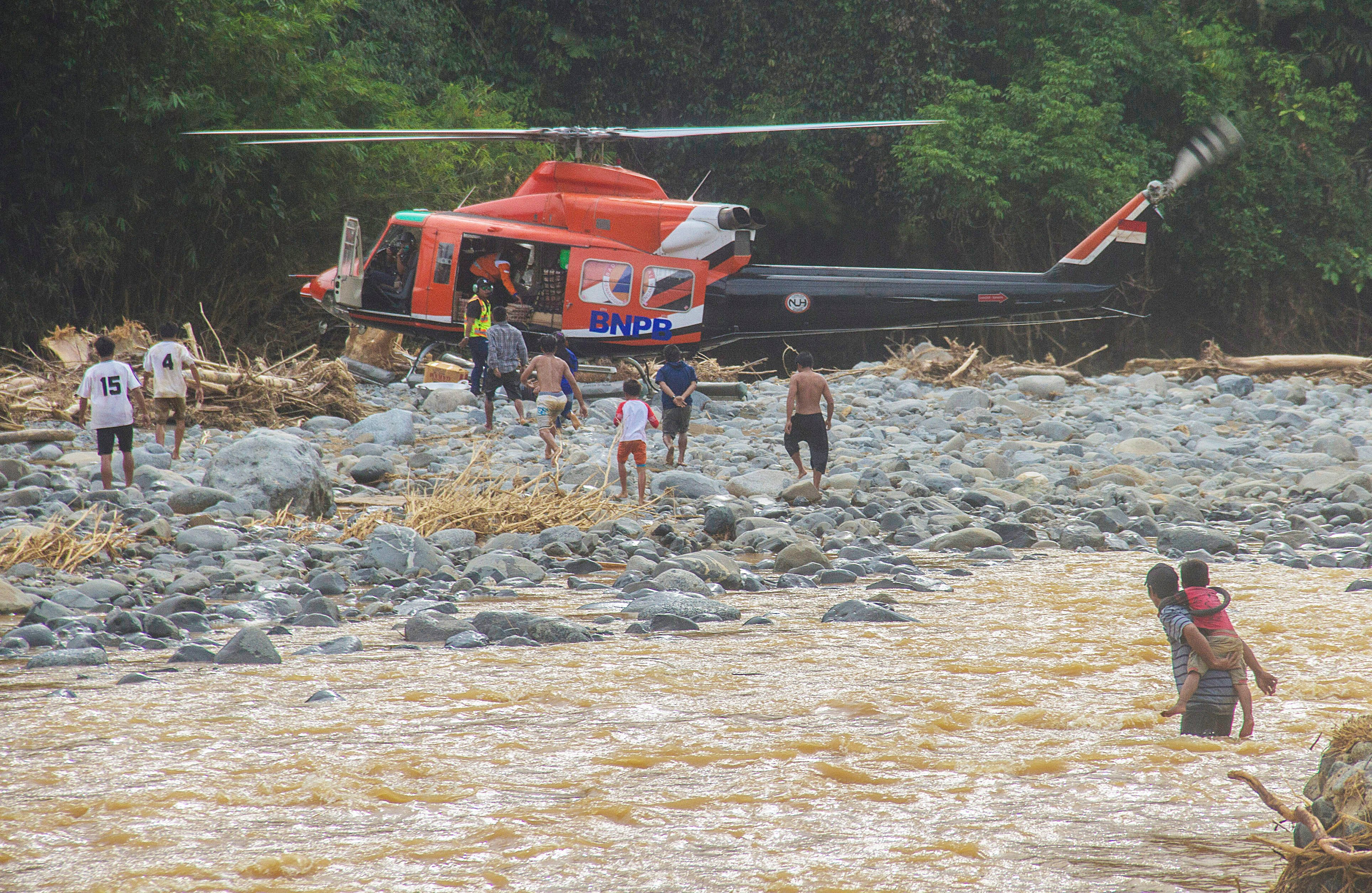Warga mendatangi helikopter BNPB saat tiba mengantarkan bantuan korban banjir di Desa Datar Ajab, Kabupaten Hulu Sungai Tengah, Kalsel.