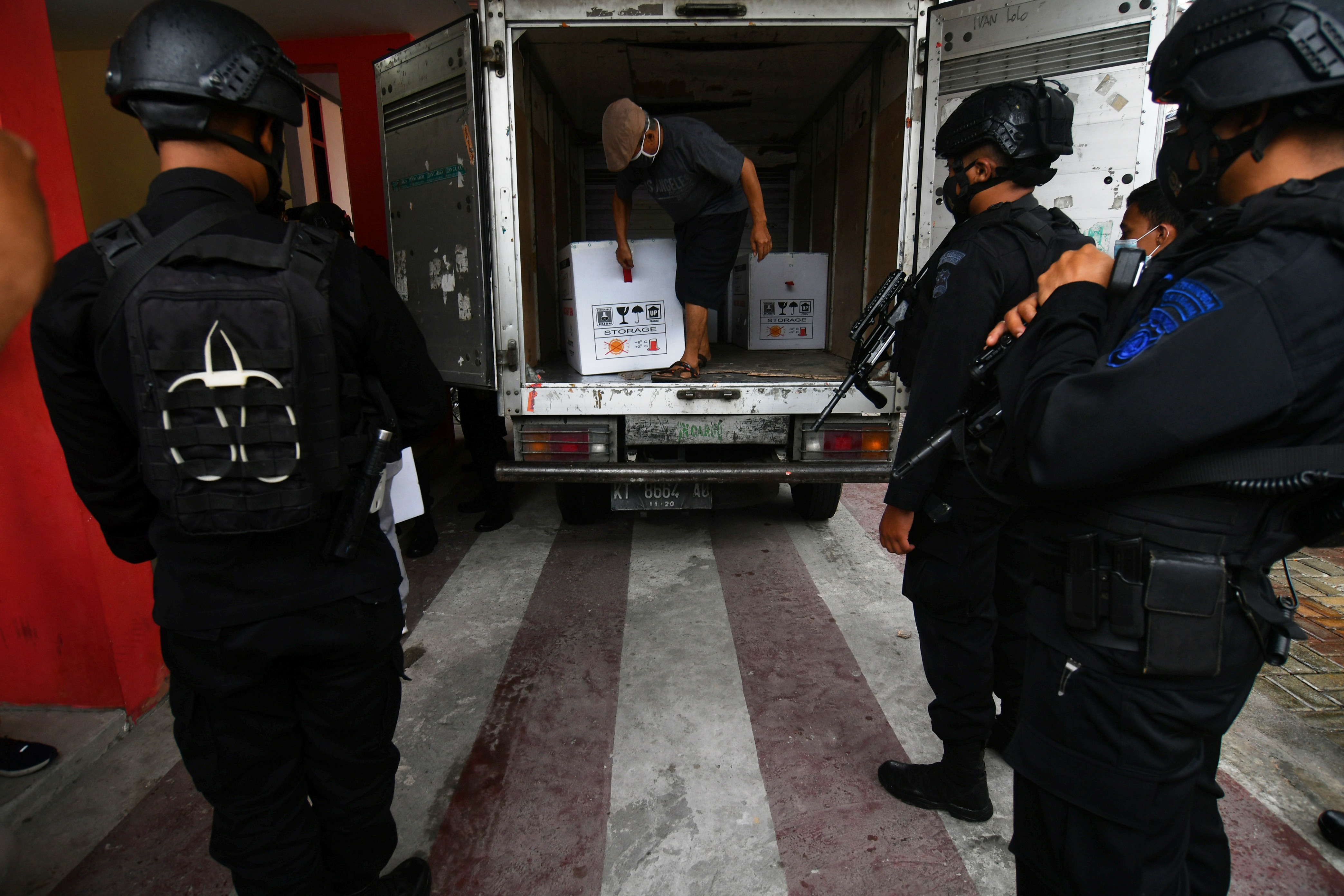 Personel Brimob menjaga truk kargo pengangkut vaksin COVID-19 Sinovac yang tiba di Gd Instalasi Farmasi Dinas Kesehatan Provinsi Sulteng.