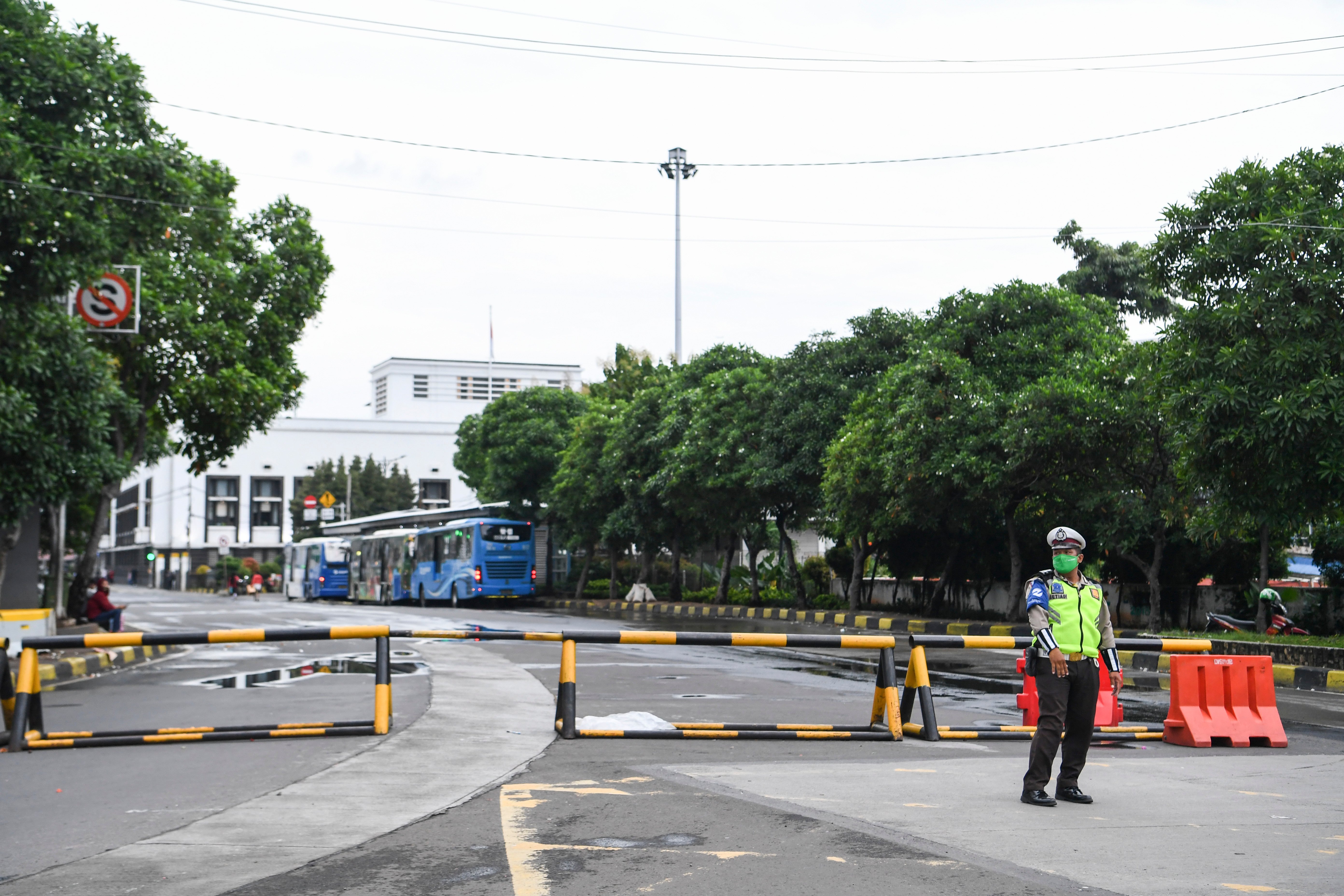 Polisi berjaga di depan Jalan Pintu Besar Utara yang ditutup di kawasan Kota Tua, Jakarta. Sejumlah akses ke Kota Tua ditutup selama PPKM.