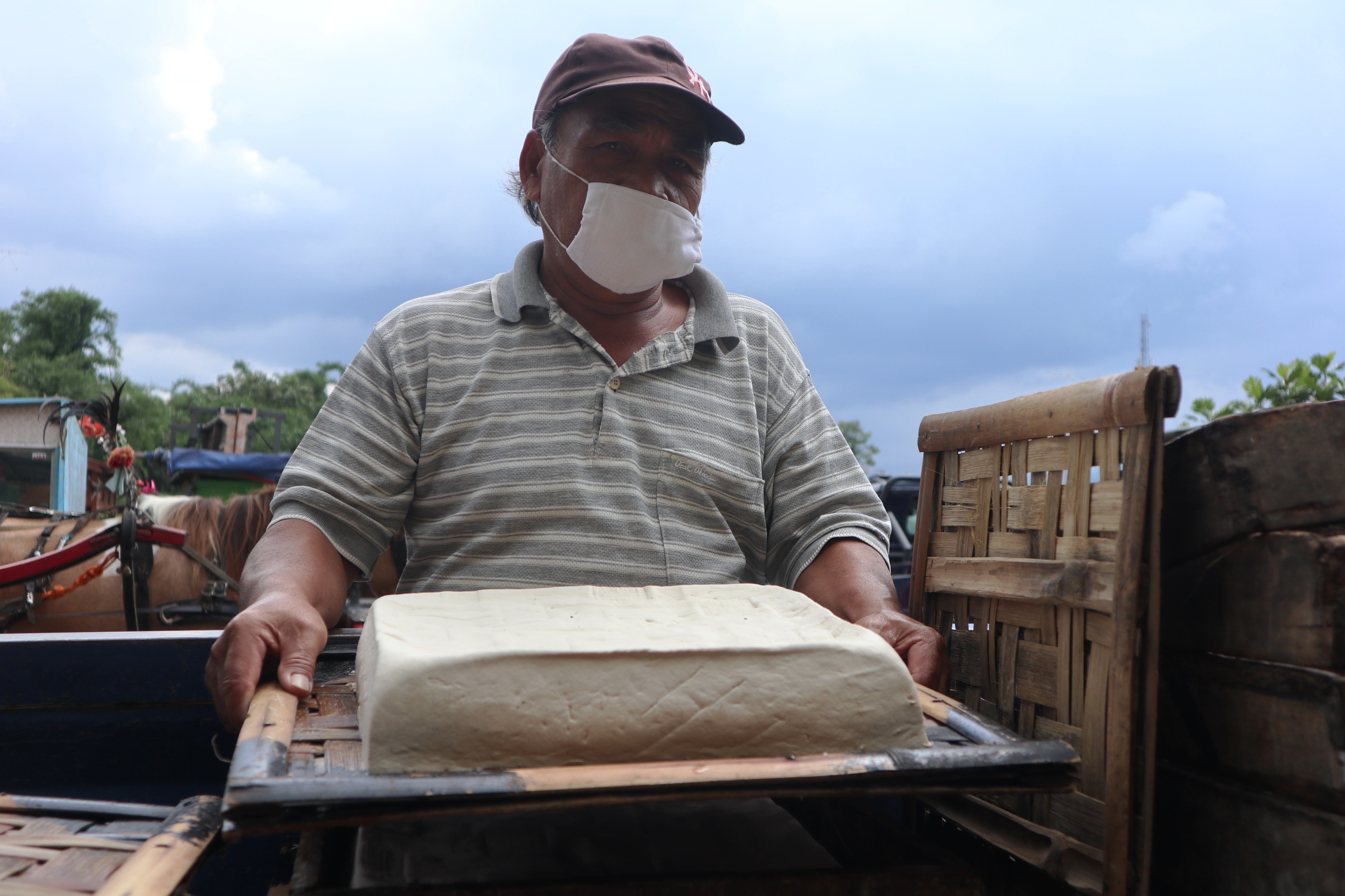 Salah seorang pedagang / pengrajin tahu di Temanggung, Jawa Tengah menunjukan papan tahu putih siap jual, Selasa (12/1/2021).