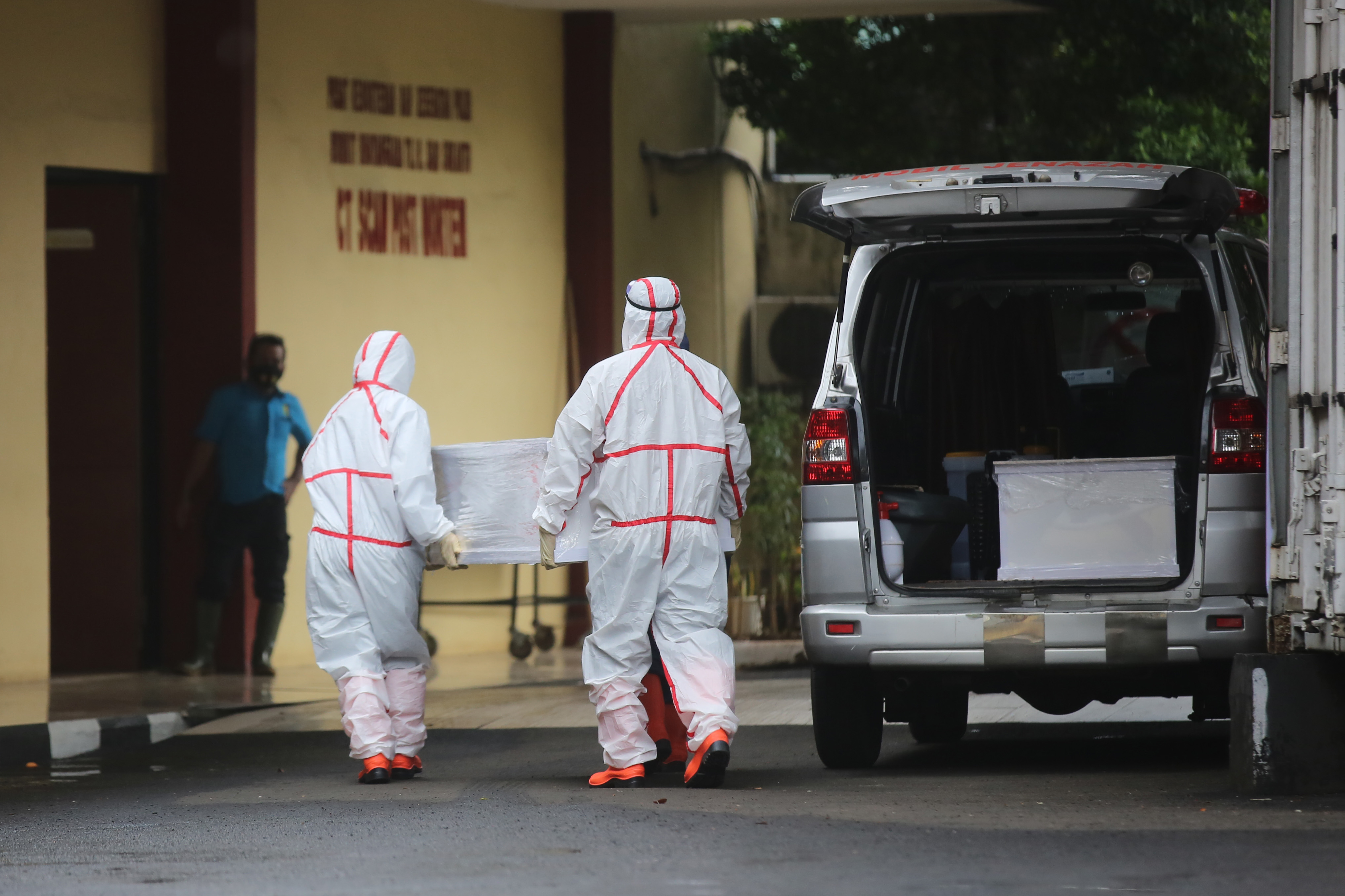 Petgas pemulasaran jenazah di RS Polri bersiap untuk membawa jenazah pasien yang meninggal akibat Covid-19