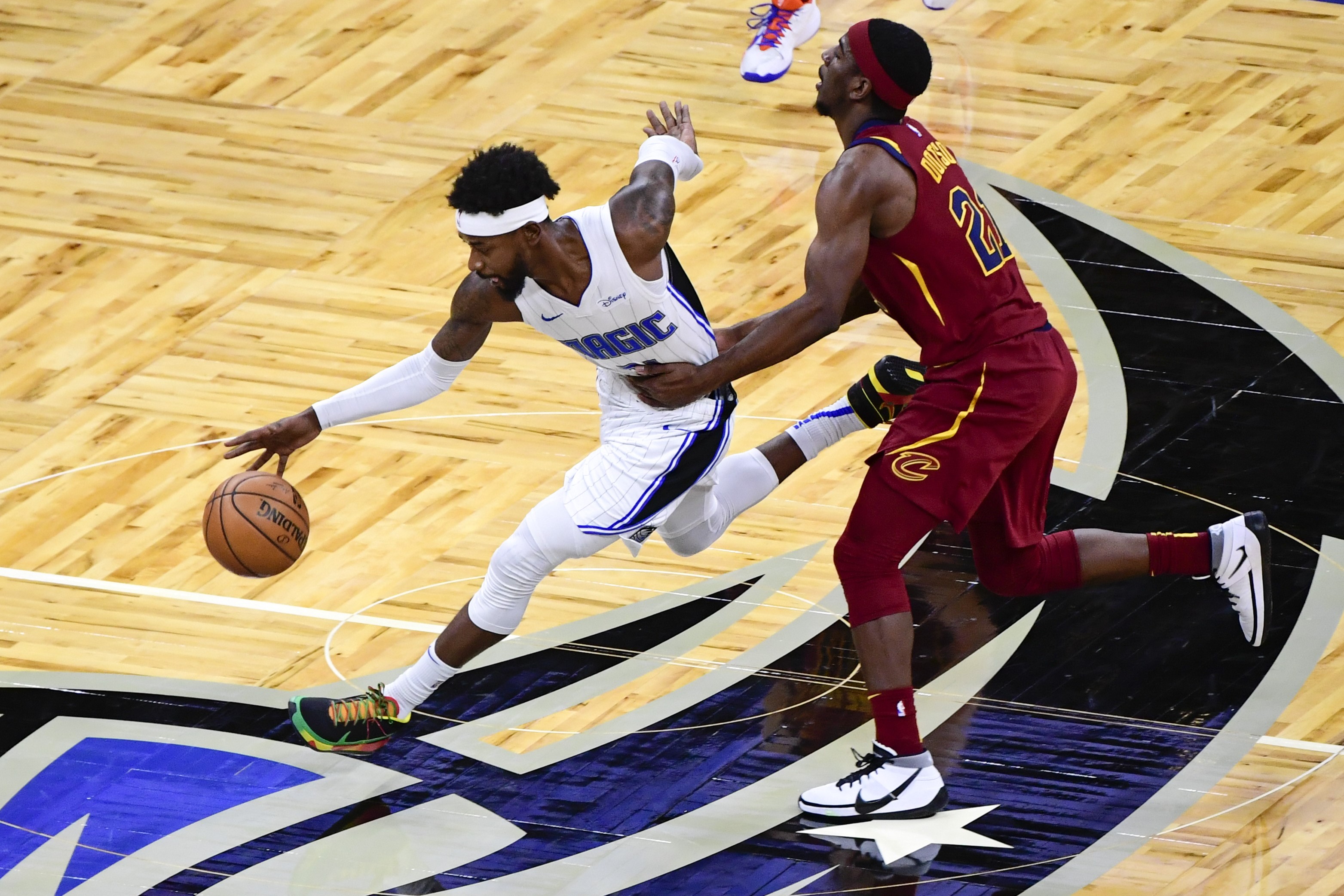 Pemain Orlando Magic Terrence Ross (kiri) melewati hadangan pemain Cleveland Cavaliers dalam laga NBA.