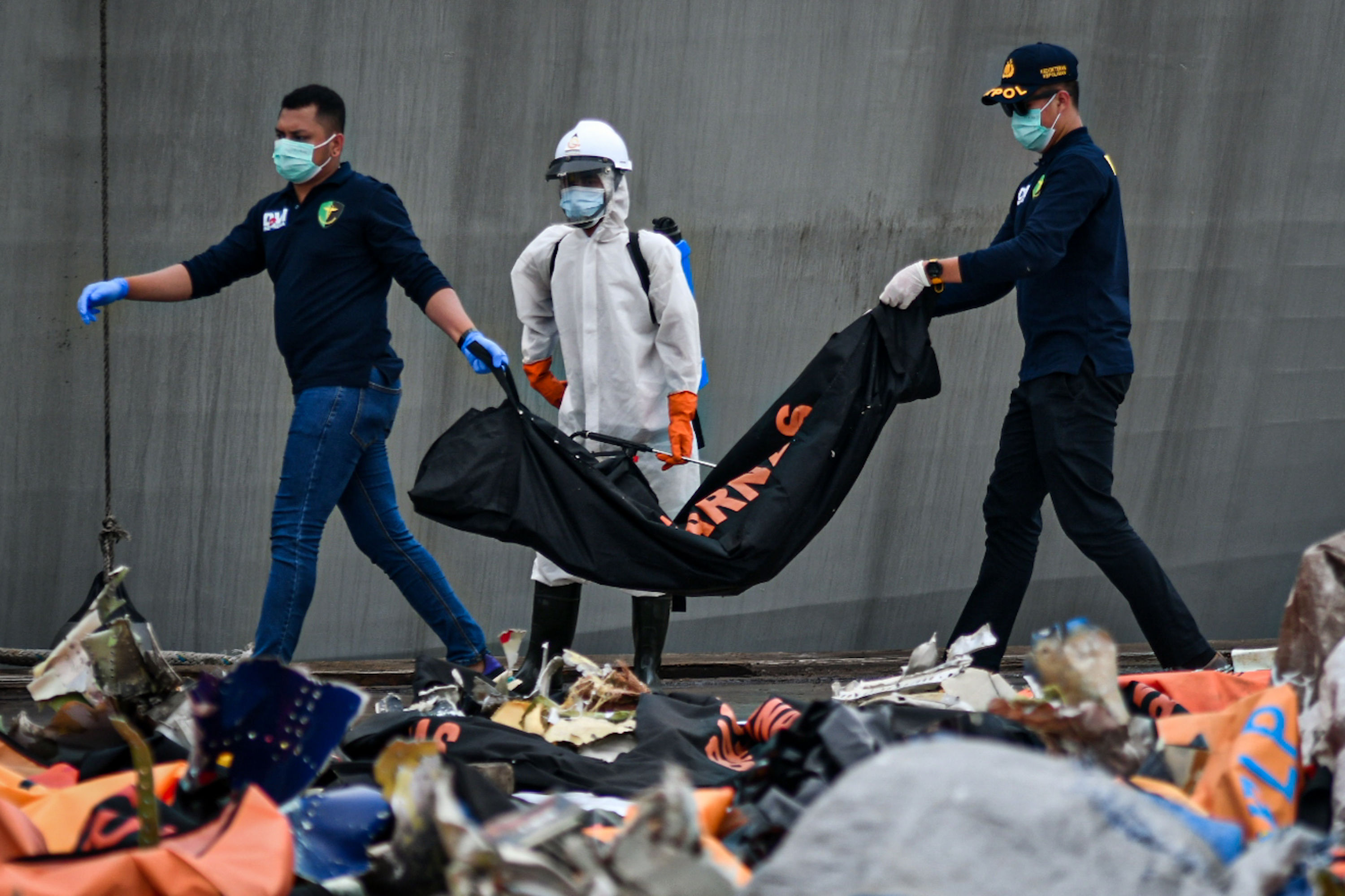 Petugas memeriksa benda-benda yang didapatkan dari pencarian jatuhnya pesawat Sriwijaya Air SJ-182.