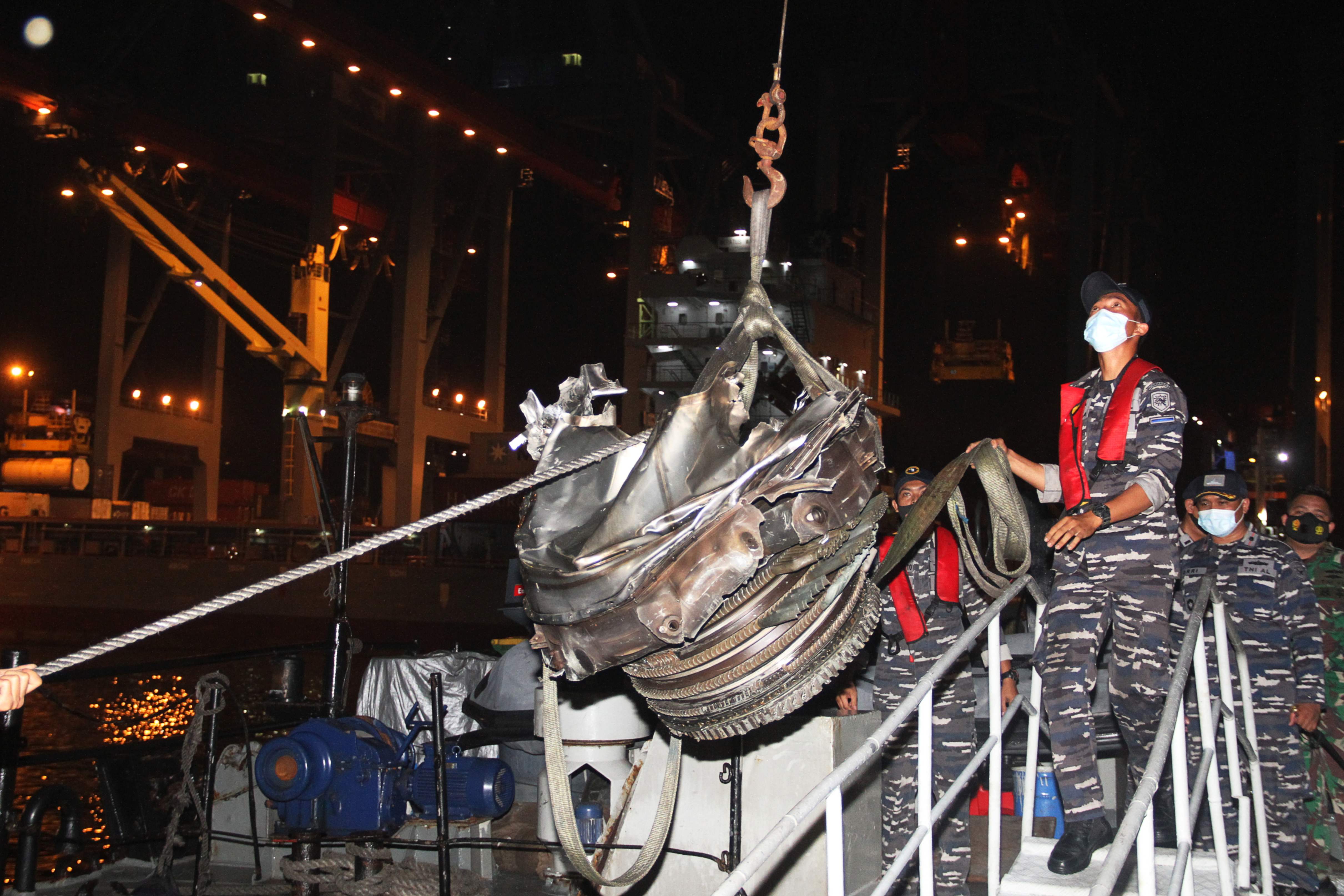 Petugas mengangkat bagian mesin dari pesawat Sriwijaya Air SJ-182 saat tiba di Teluk Jakarta.