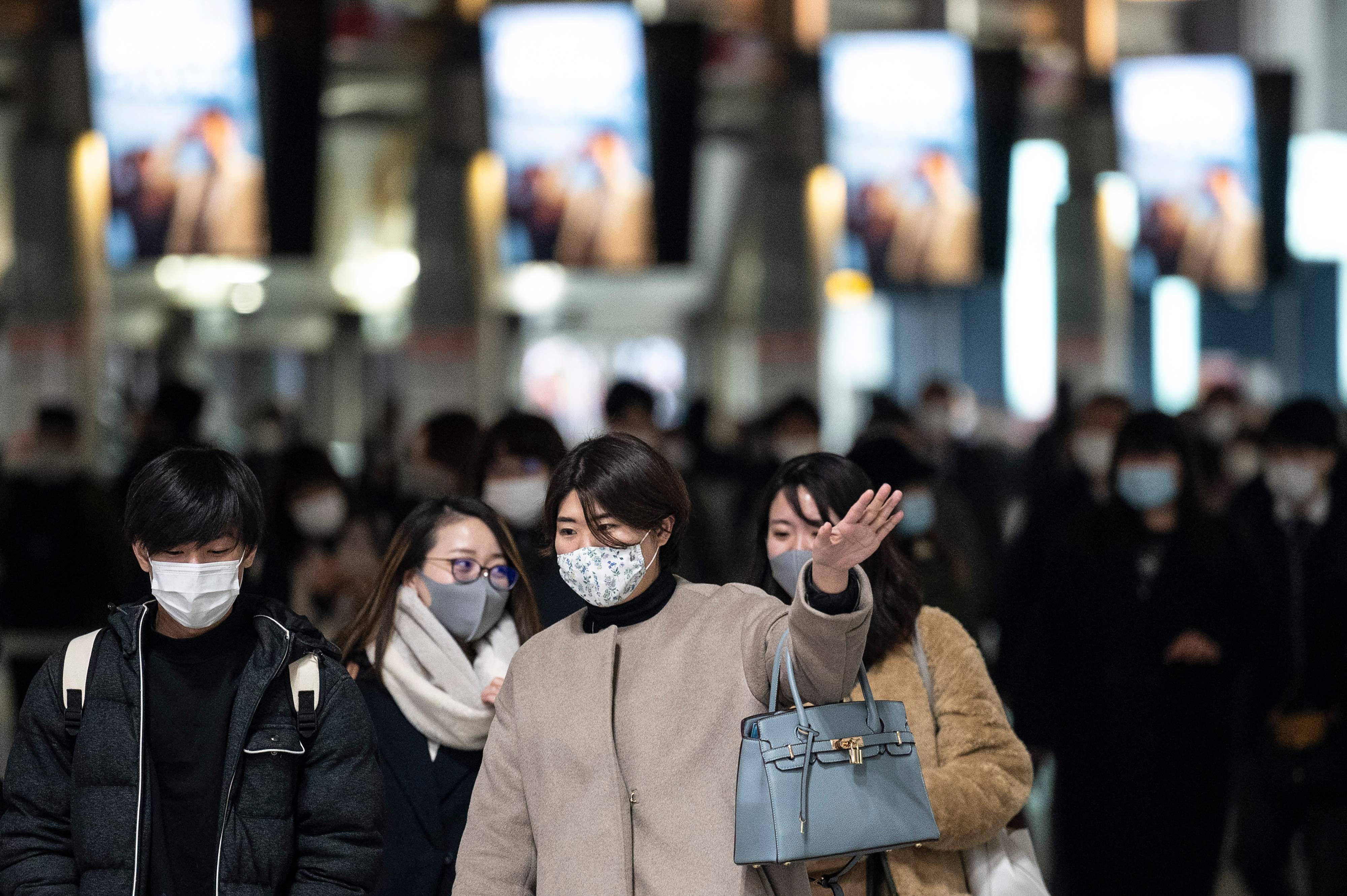 Warga yang mengenakan masker berjalan di Stasiun Shinagawa, Kota okyo, Jepang.