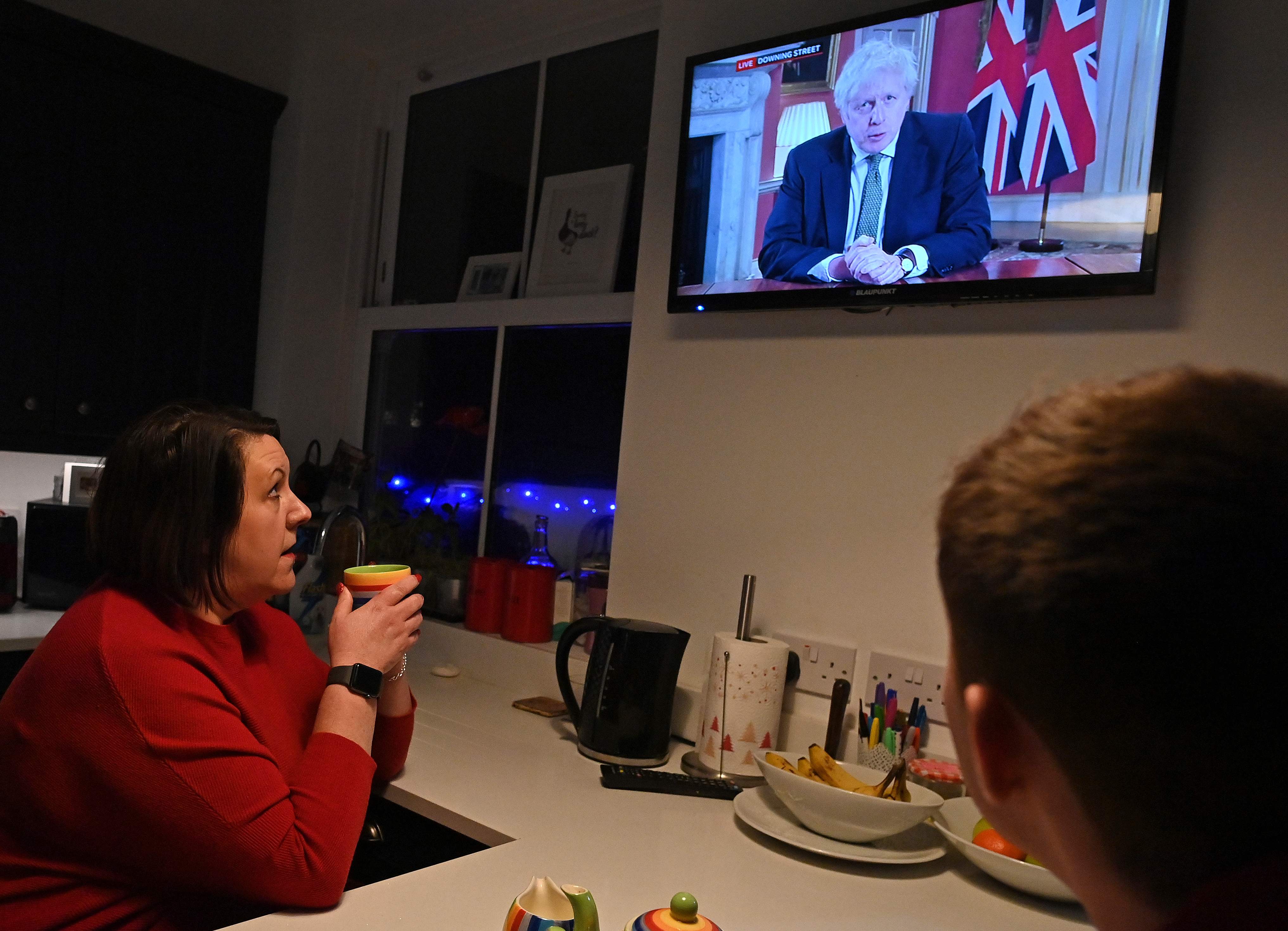 Warga menonton pengumuman lockdown baru oleh PM Inggris Boris Johnson.
