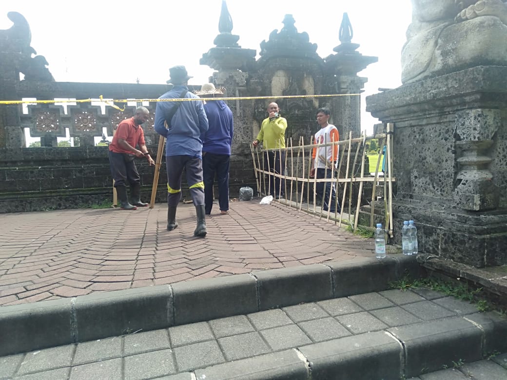 Pintu masuk lapangan Renon dipagari kayu bambu karena garis polisi yang dipasang selalu dibongkar warga.