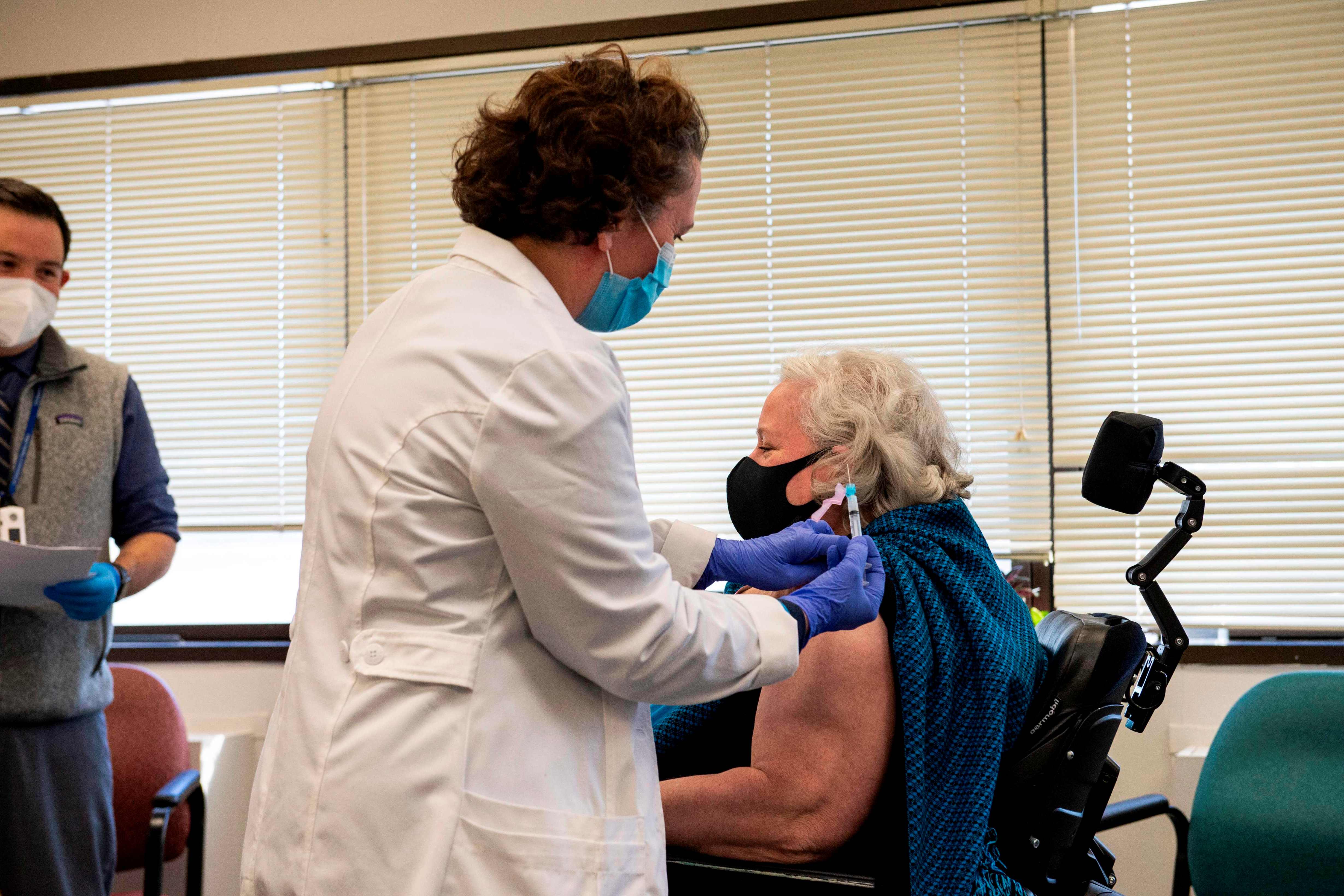 Tenaga kesehatan memberikan suntikan vaksin covid-19 Moderna kepada Christine Griffin, seorang veteran, akhir Desember lalu.