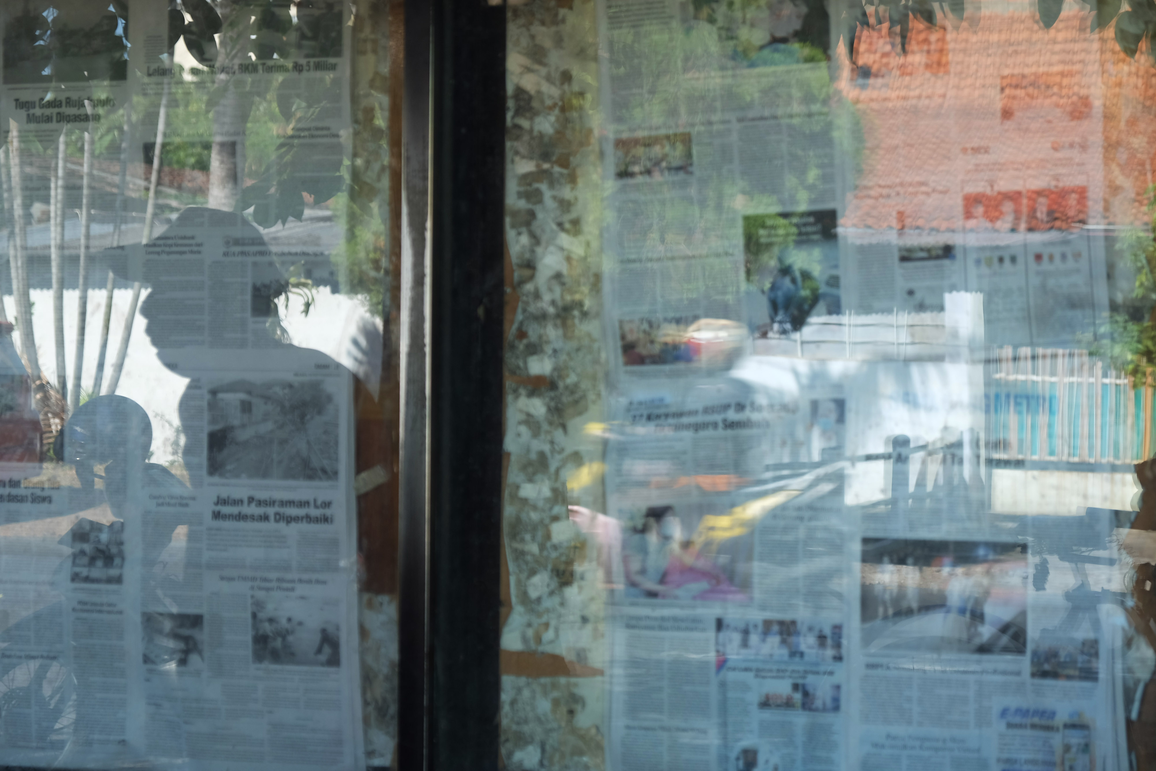  Warga membaca koran yang dipajang di salah satu kantor surat kabar di Solo, Jawa Tengah, Selasa (29/9/2020)