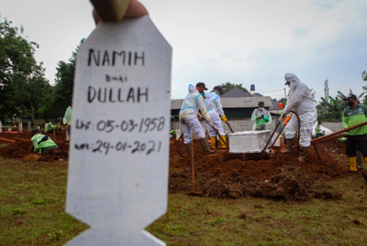 Petugas memakamkan jenazah COVID-19 di TPU Bambu Apus, Jakarta, Minggu (24/1/2021)