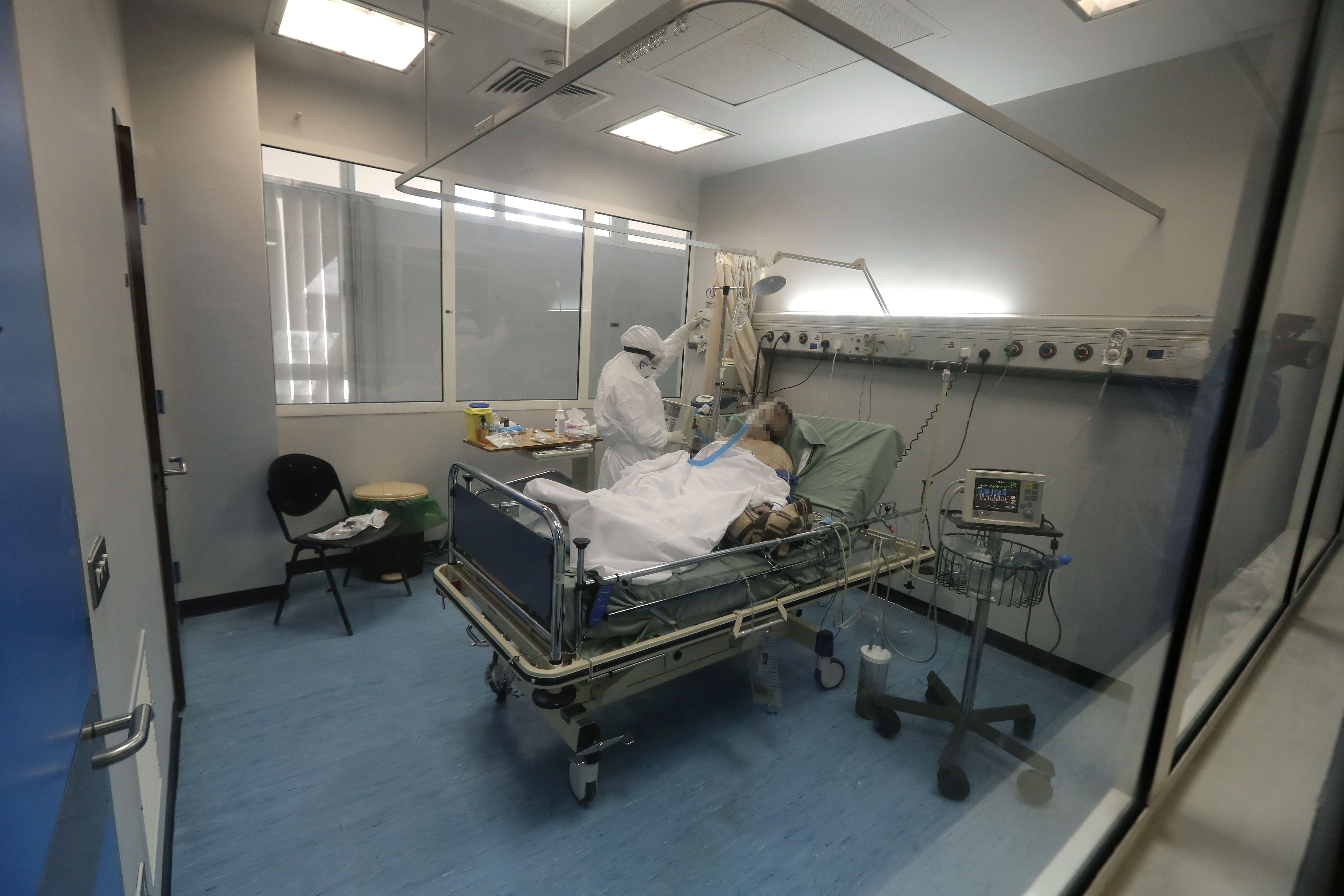 Seorang perawat merawat pasien yang menderita penyakit virus korona (COVID-19) di unit perawatan intensif yang terisolasi di rumah sakit 