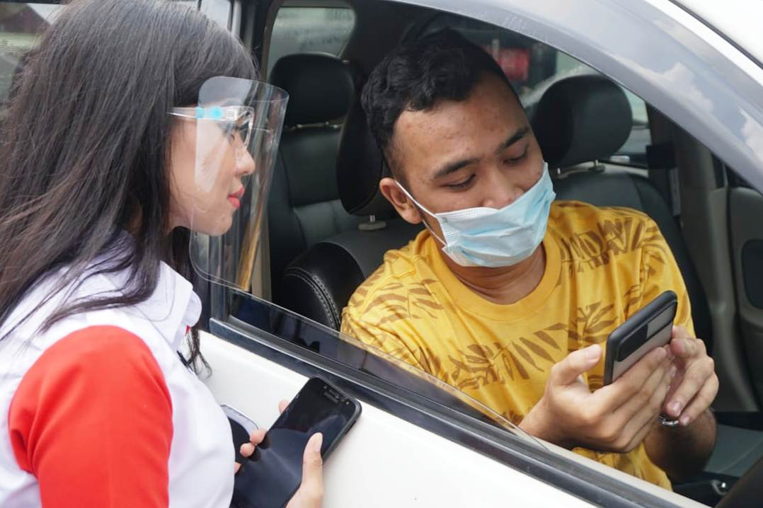 Petugas Mobile Booth Pertamina (kiri) sedang menjelaskan penggunaan aplikasi MyPertamina kepada konsumen BBM di SPBU COCO Polonia, Medan.