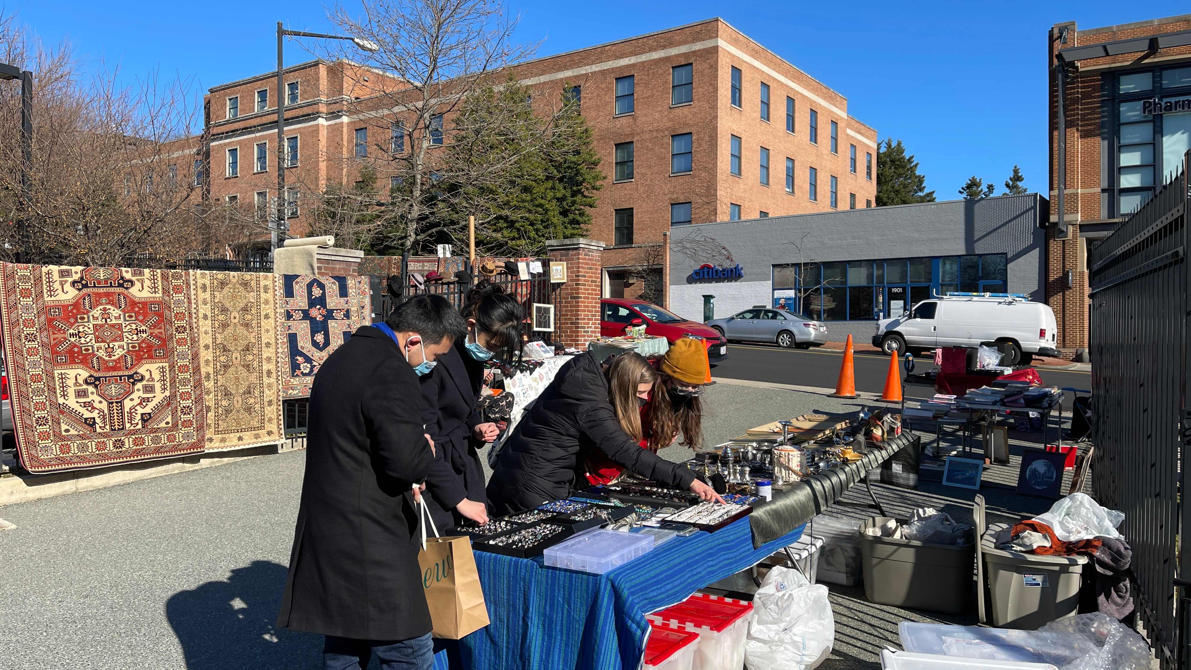 Warga mengenakan masker saat berbelanja di sebuah pasar loak di Georgetown, Washington DC, AS.